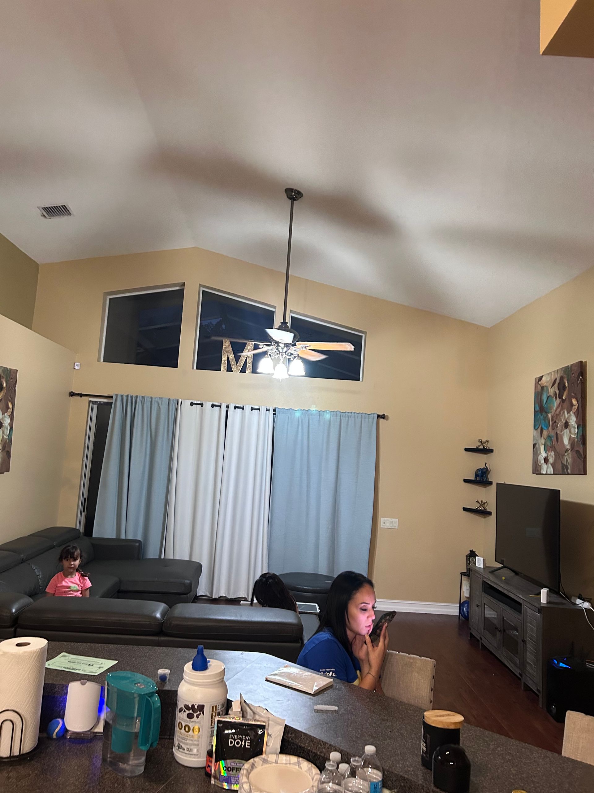 Living room with a woman on the phone, a child on the couch, and a TV.