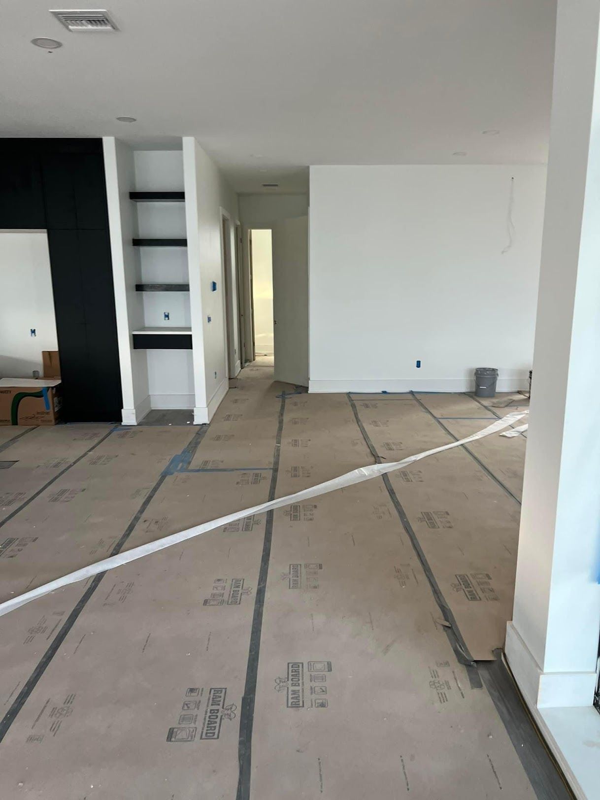 A large empty room with a lot of cardboard on the floor.