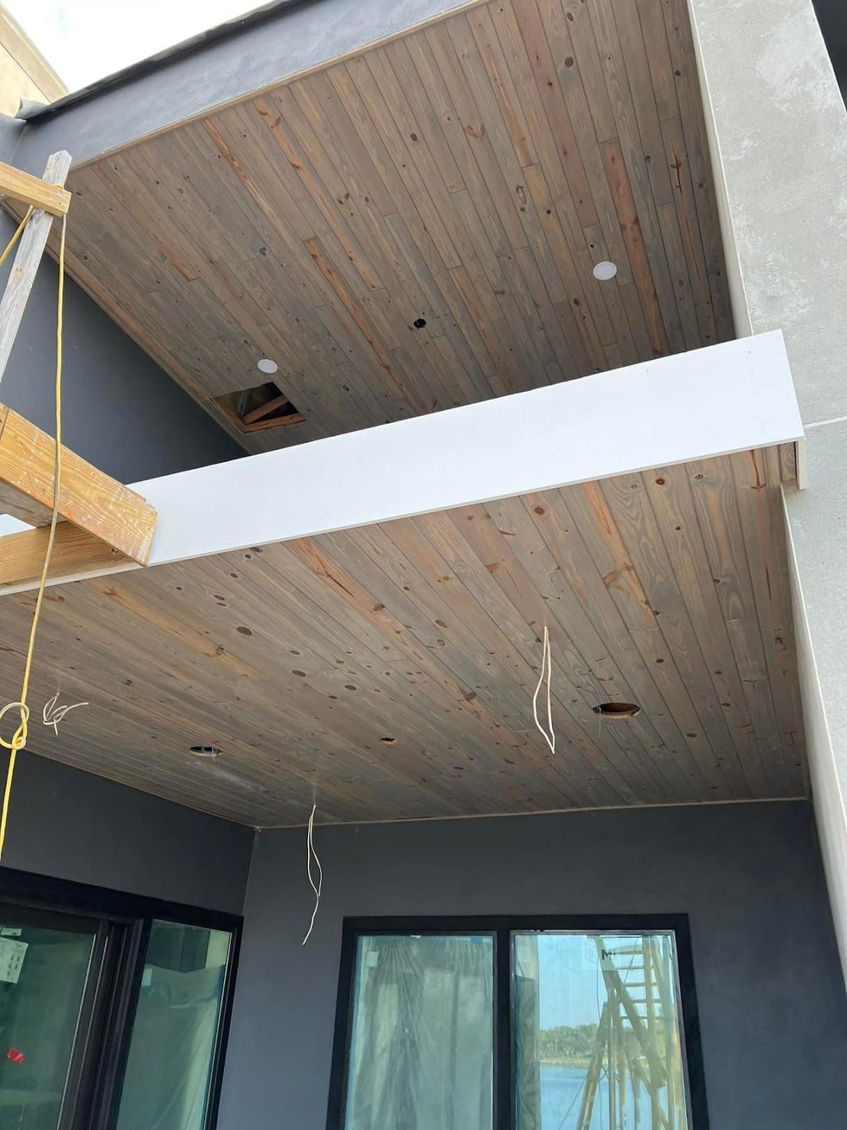 A wooden ceiling is being installed on a house under construction.