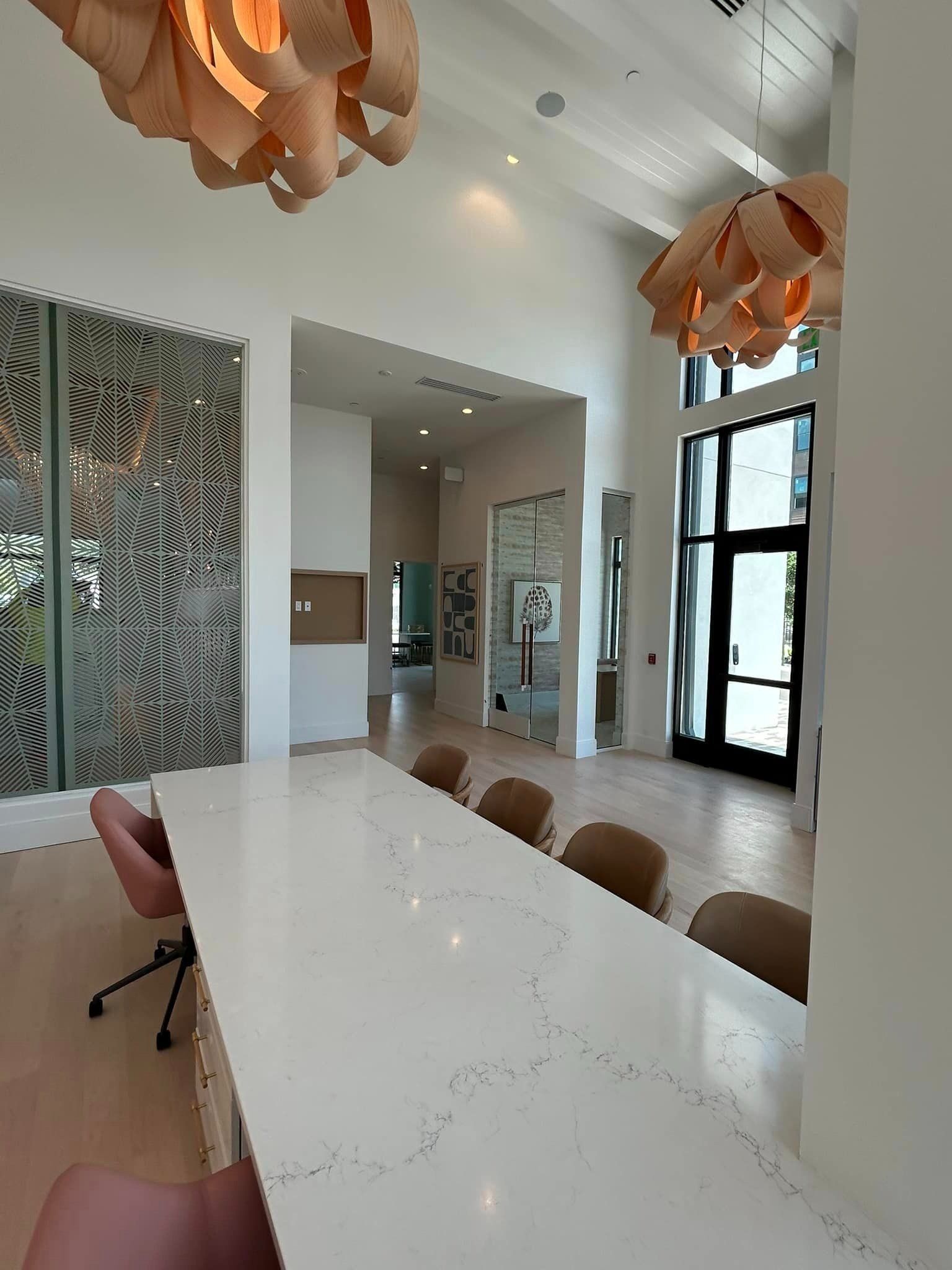 A large dining room with a long table and chairs.