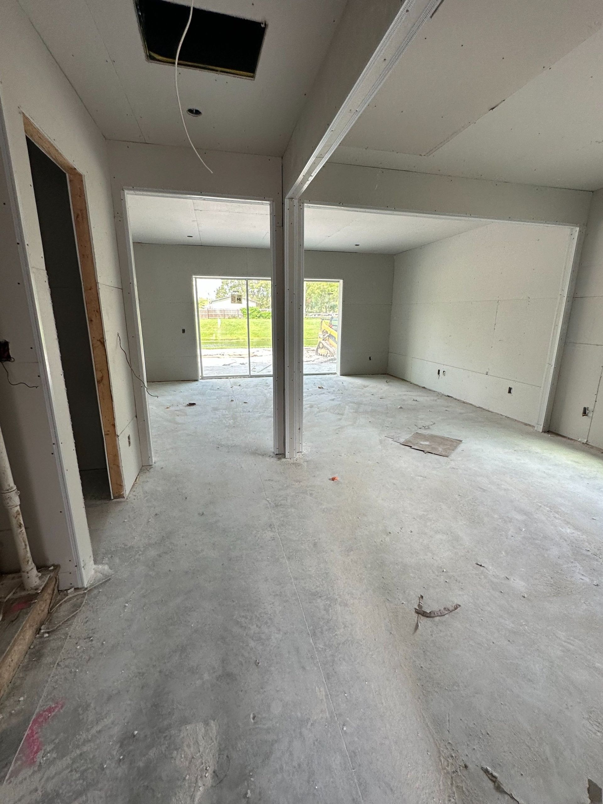 A large empty room with a concrete floor and a ceiling.