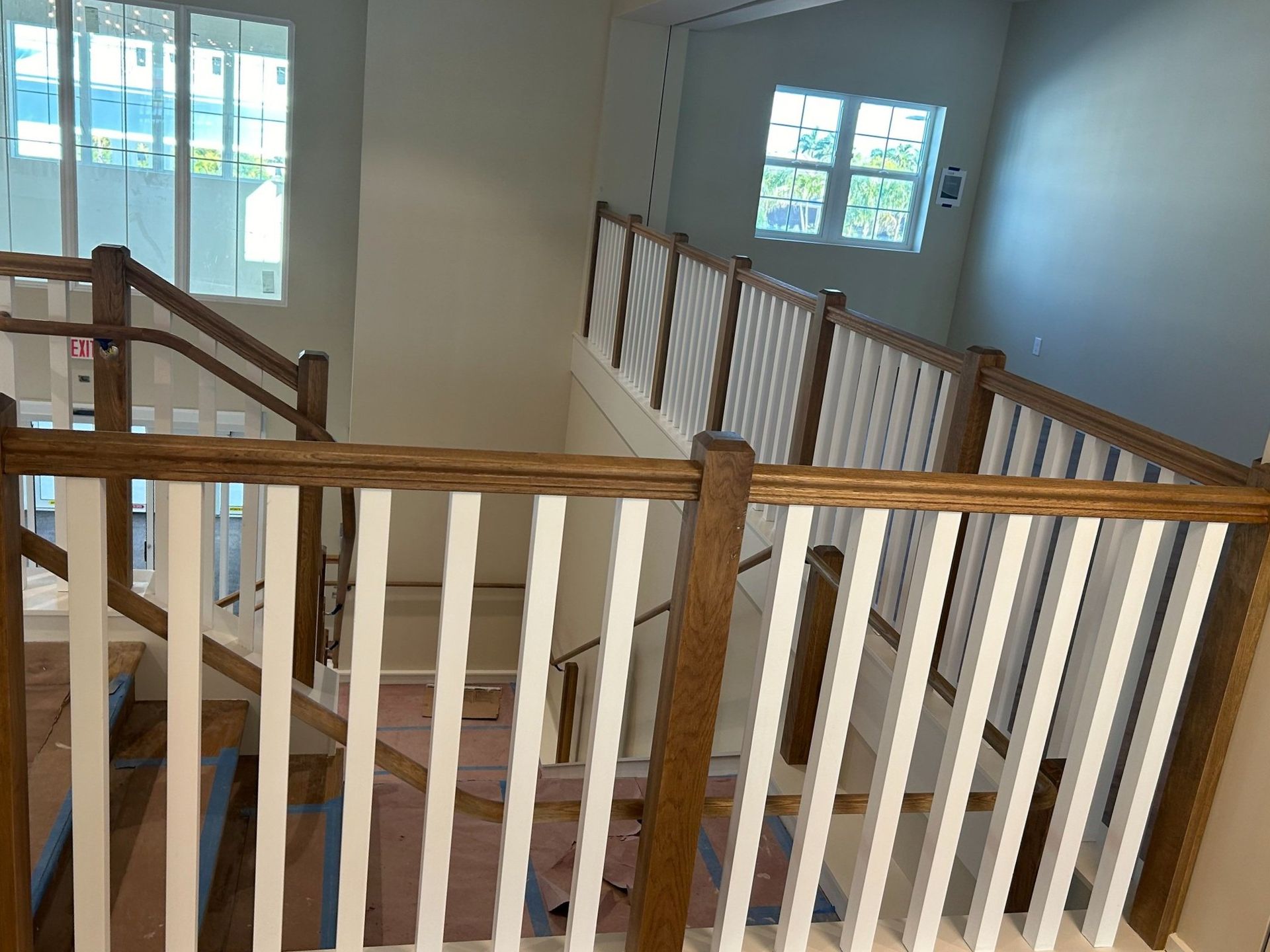 A staircase with a wooden railing and white railings