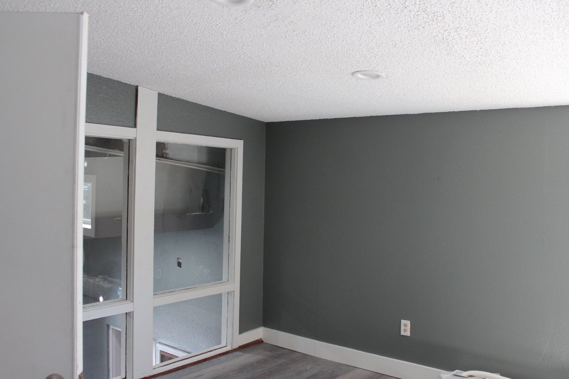 An empty room with gray walls and a window.