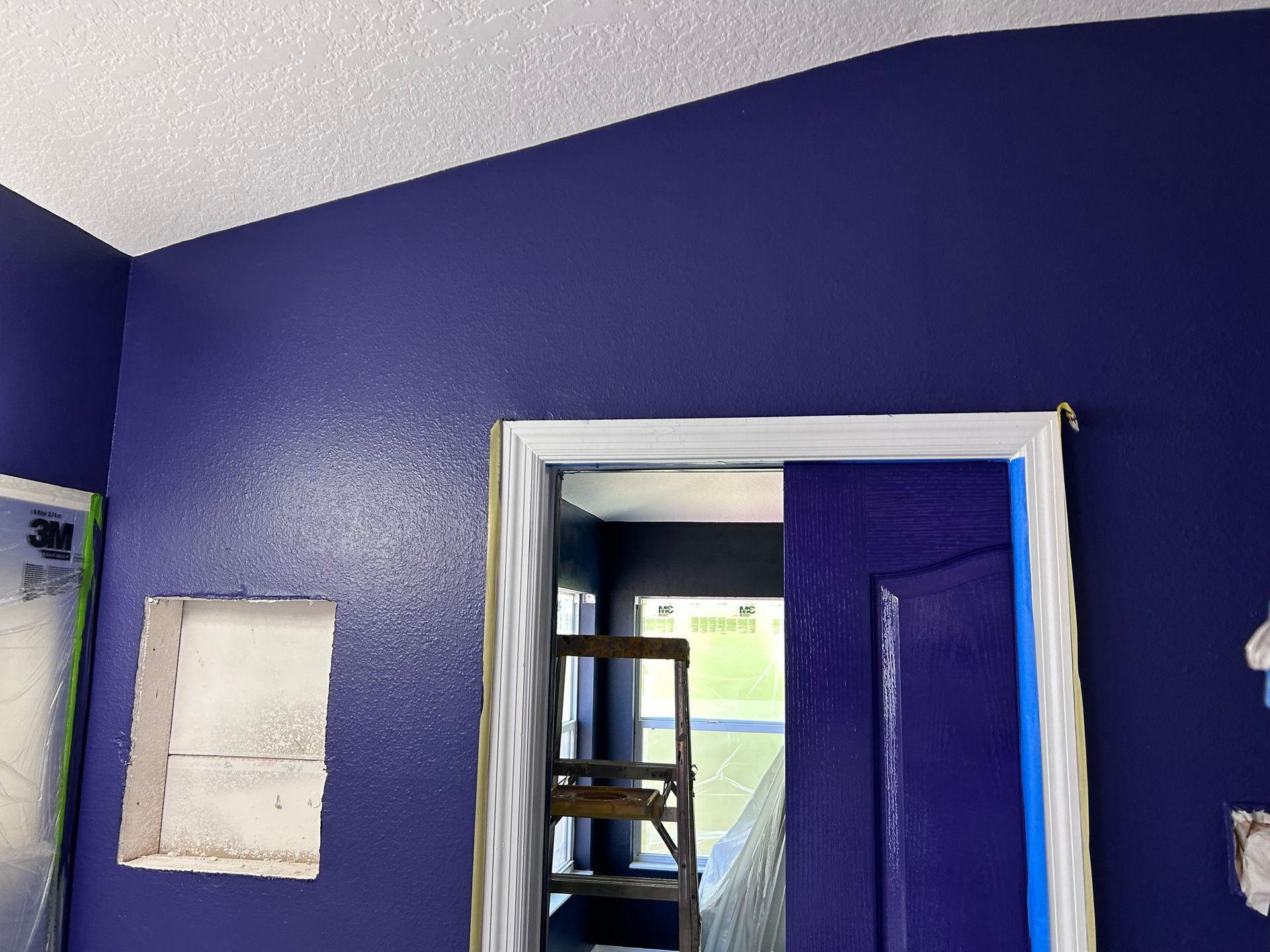 A room with purple walls and a blue door