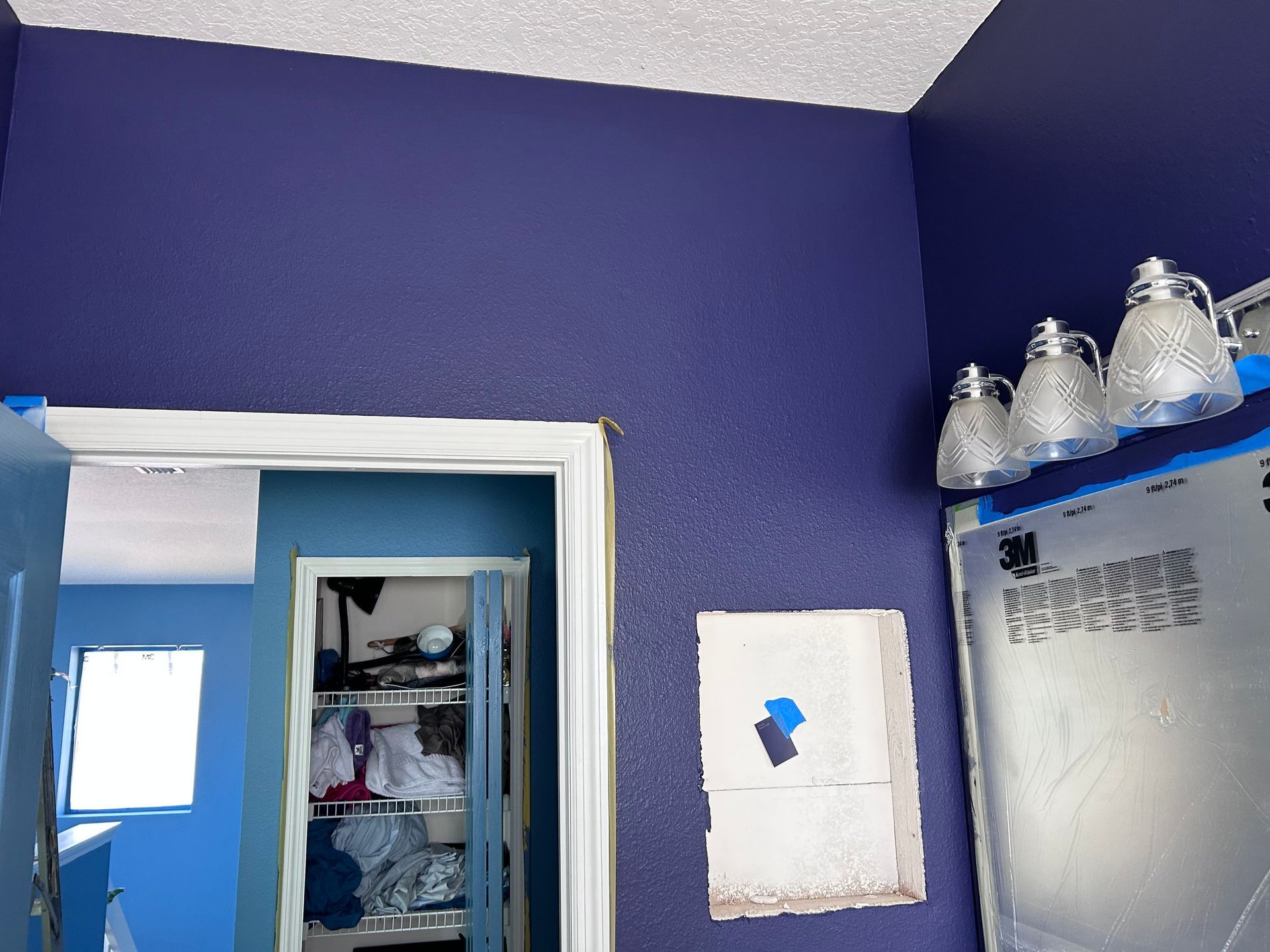 A bathroom with purple walls and a mirror
