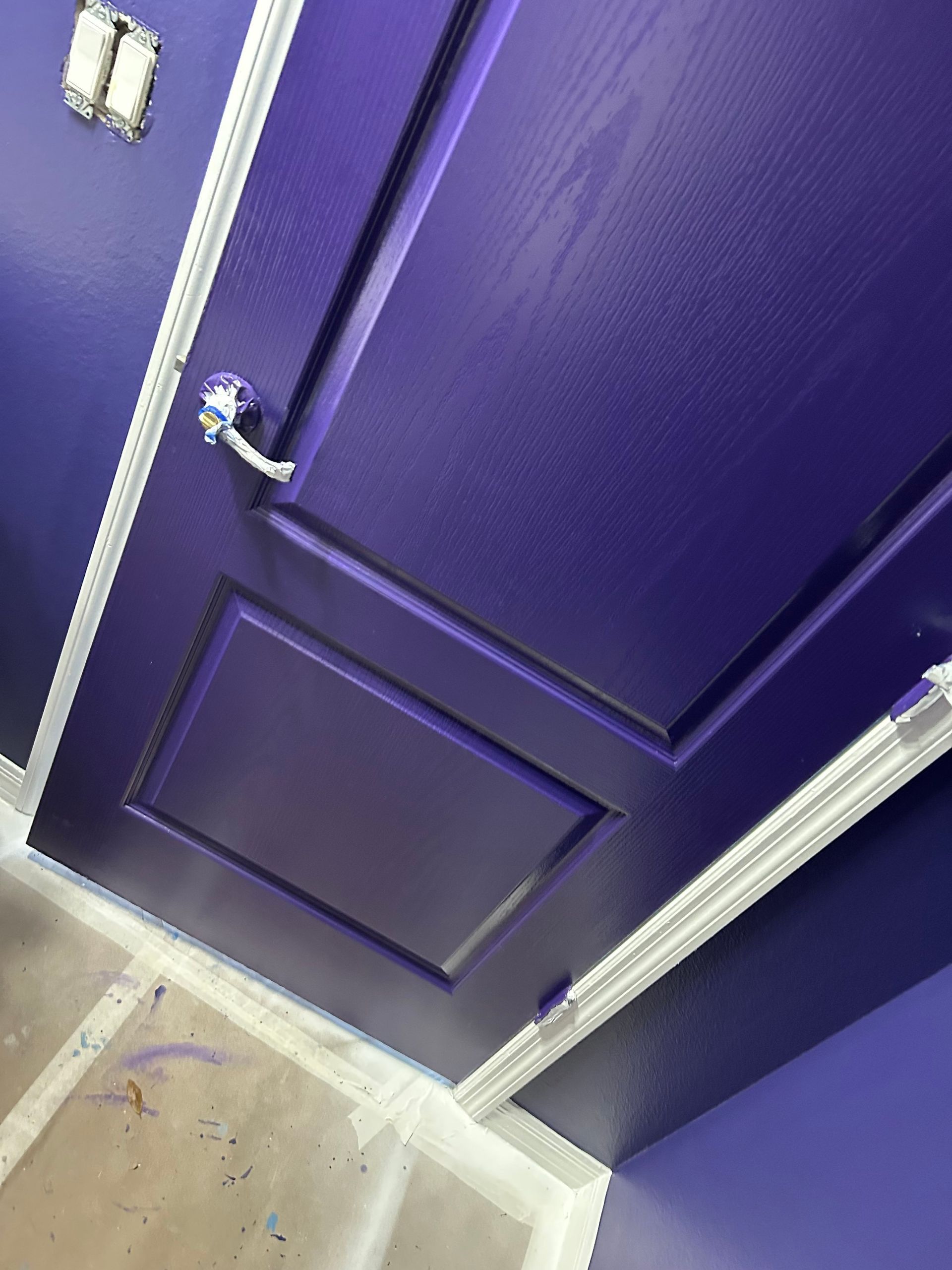 A purple door in a room with purple walls