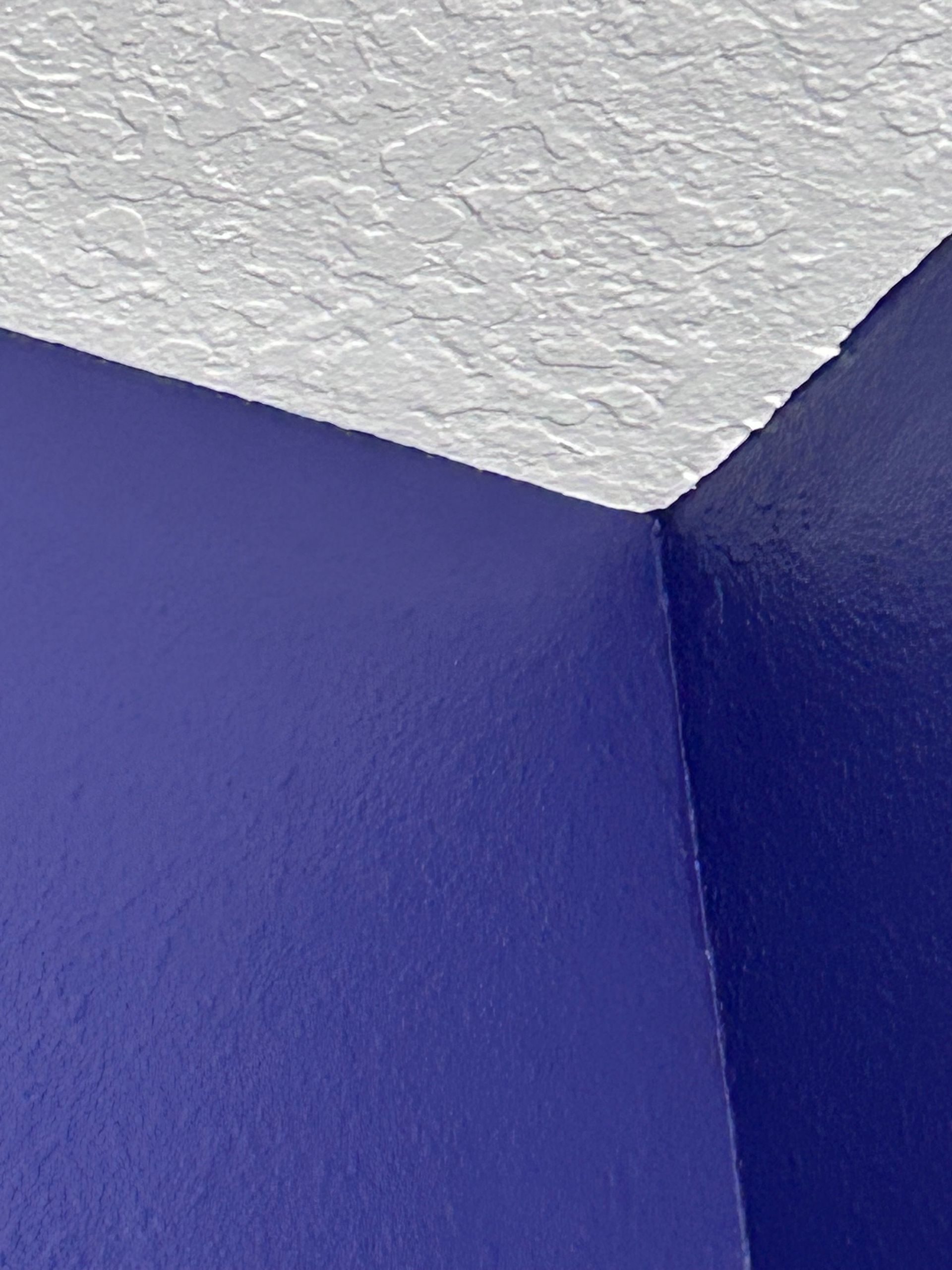 A corner of a room with blue walls and a white ceiling.