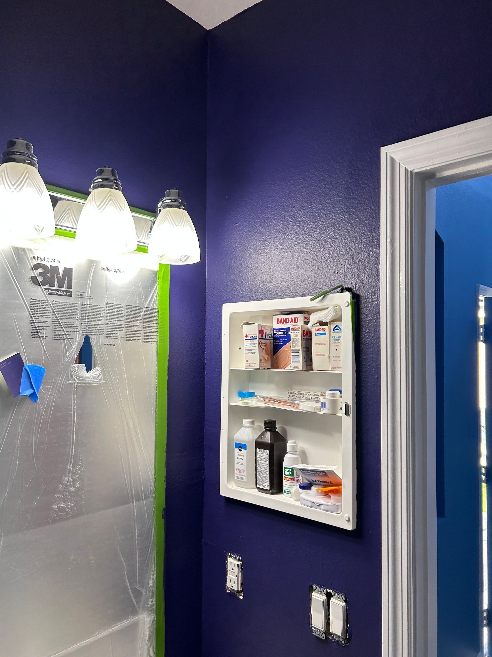 A bathroom with blue walls and a medicine cabinet.