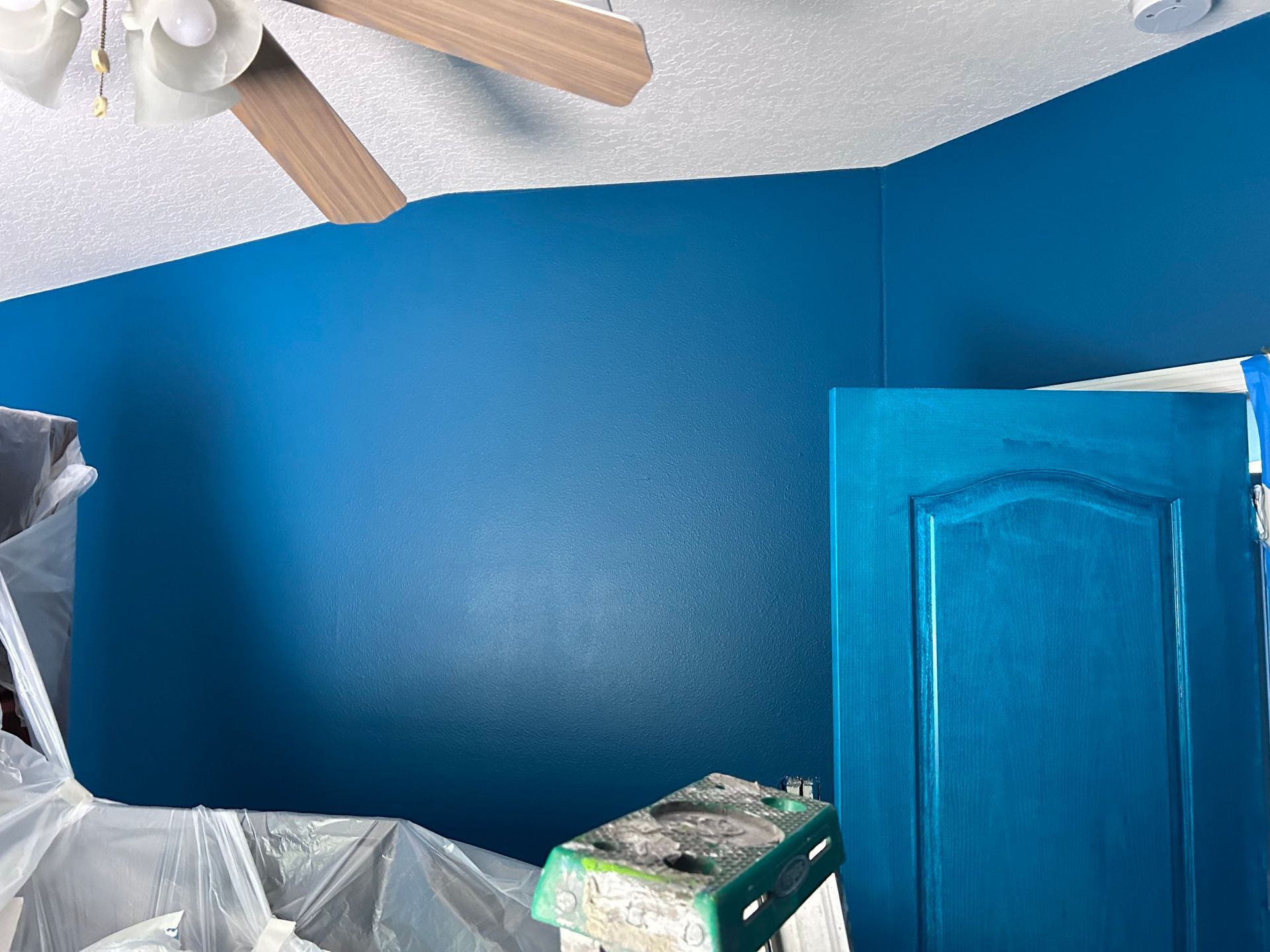 A room with blue walls and a ceiling fan.