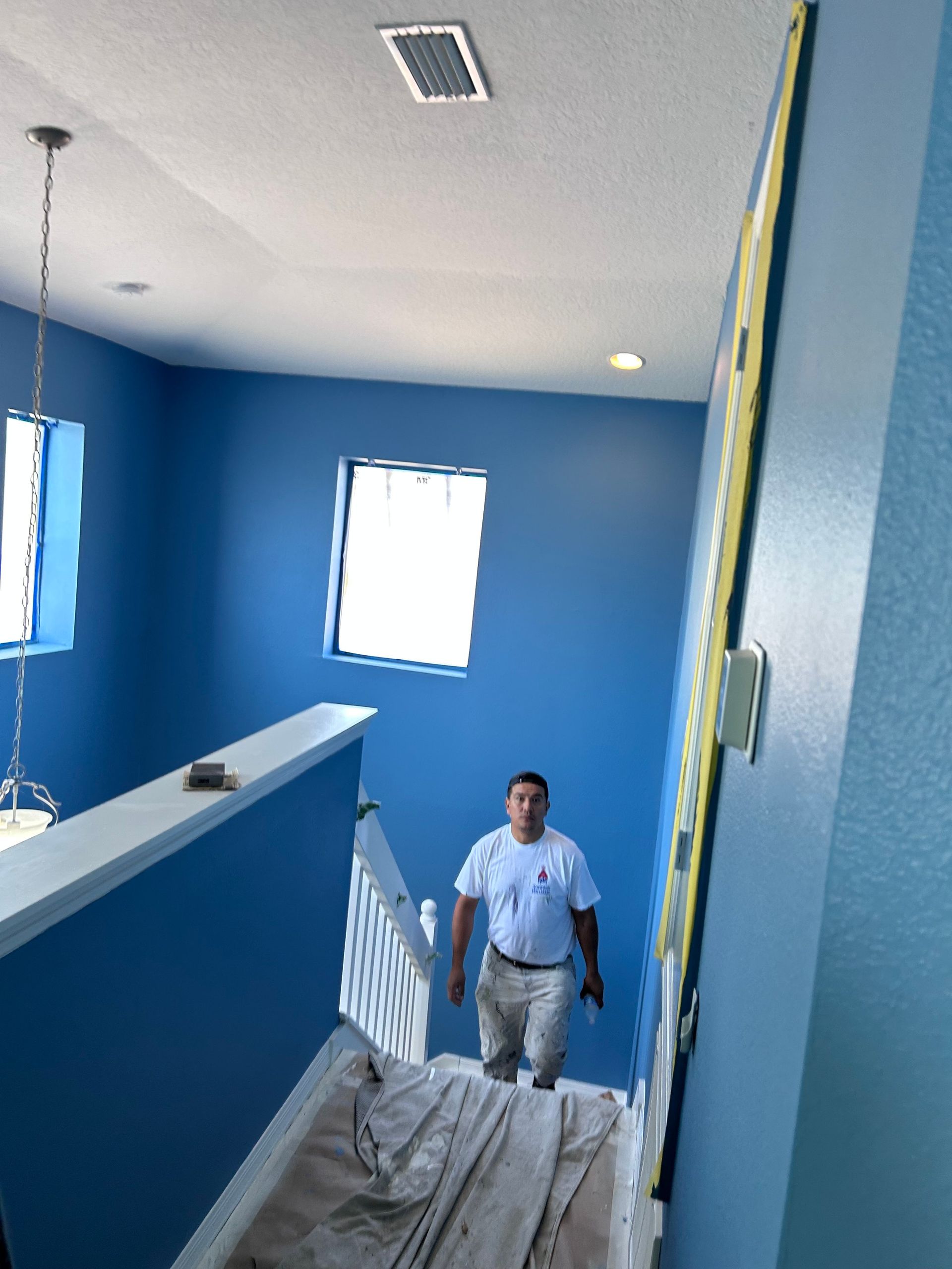 A man is walking down a set of blue stairs