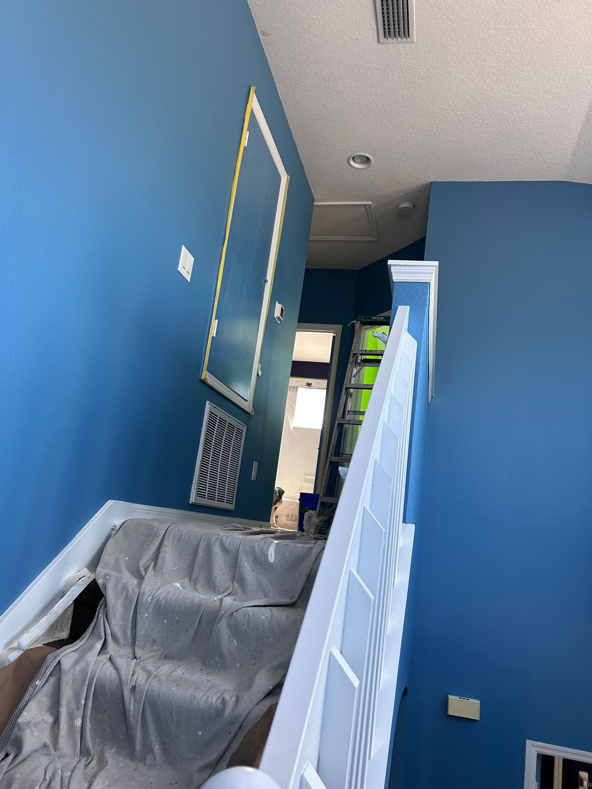 A staircase with blue walls and a white railing