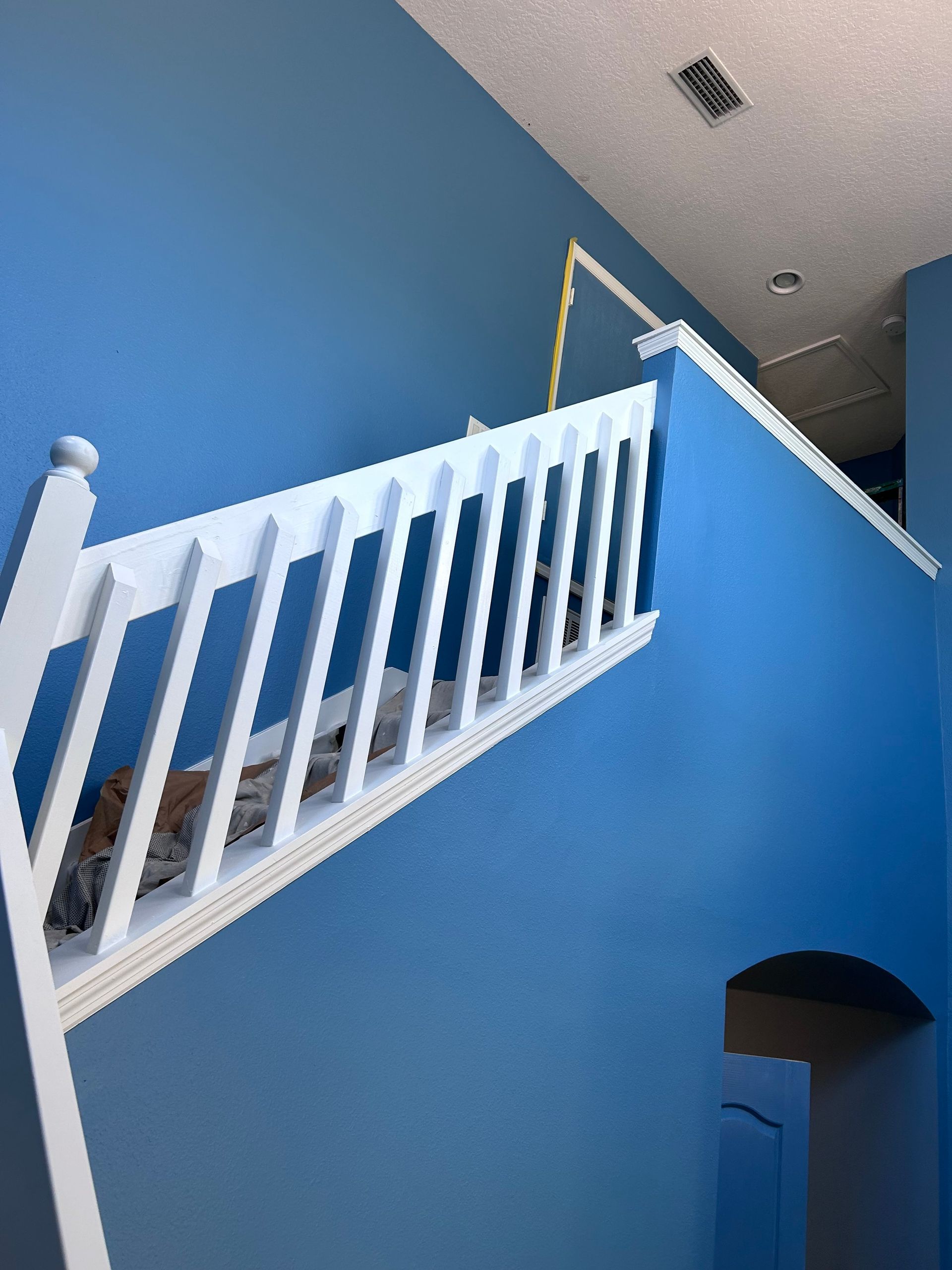 A staircase with blue walls and a white railing