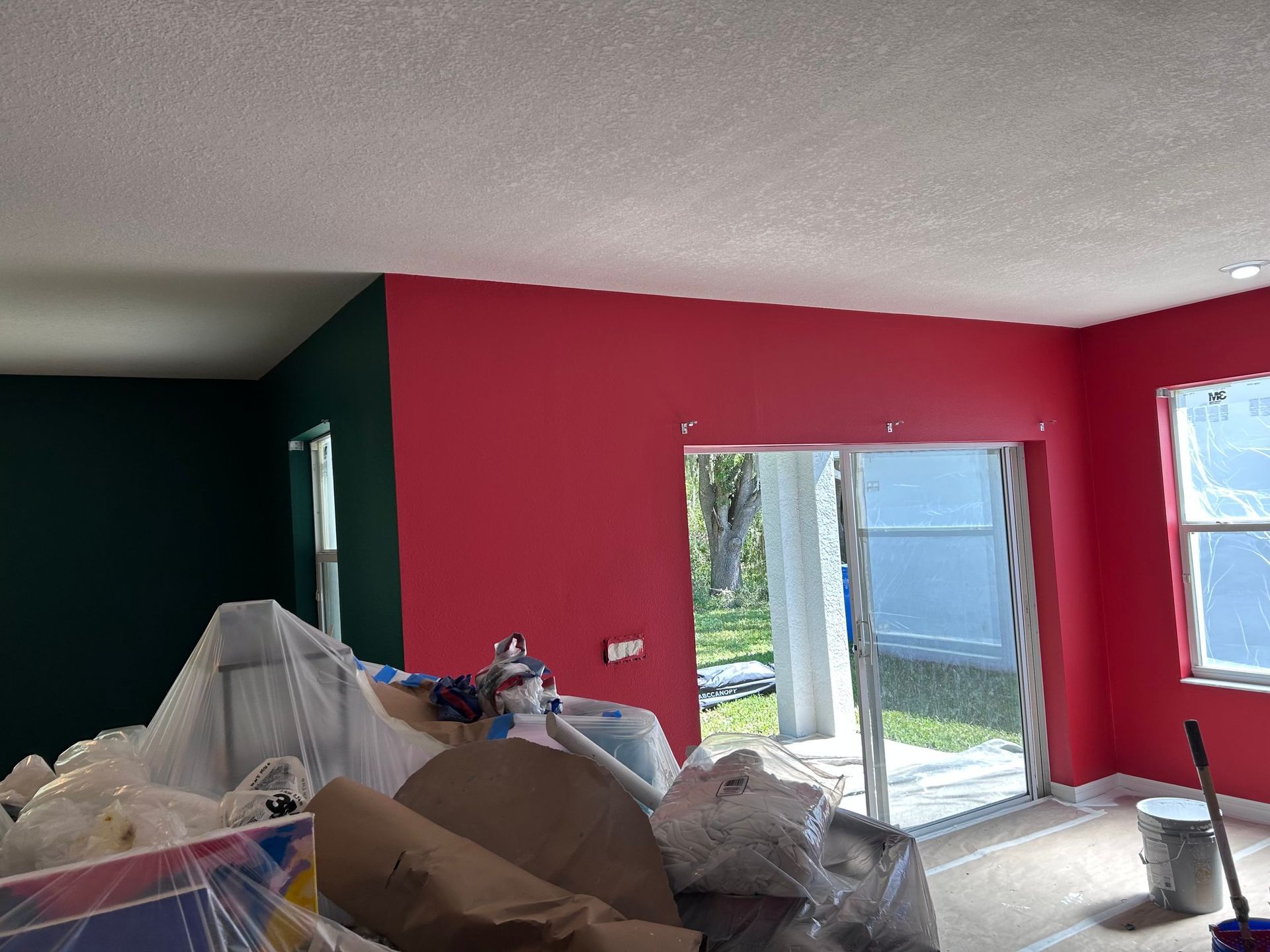A room with red walls and green walls is being painted.
