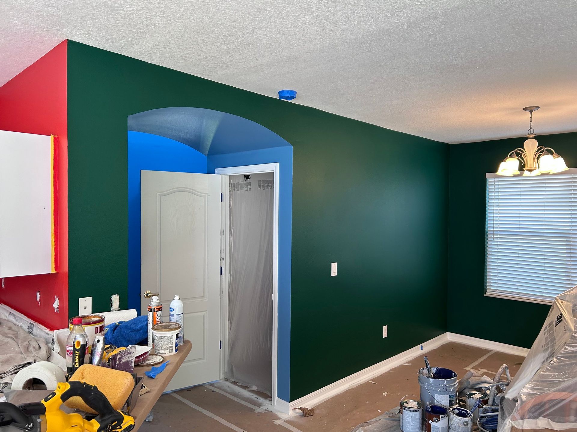 A room that is being painted with green and blue walls