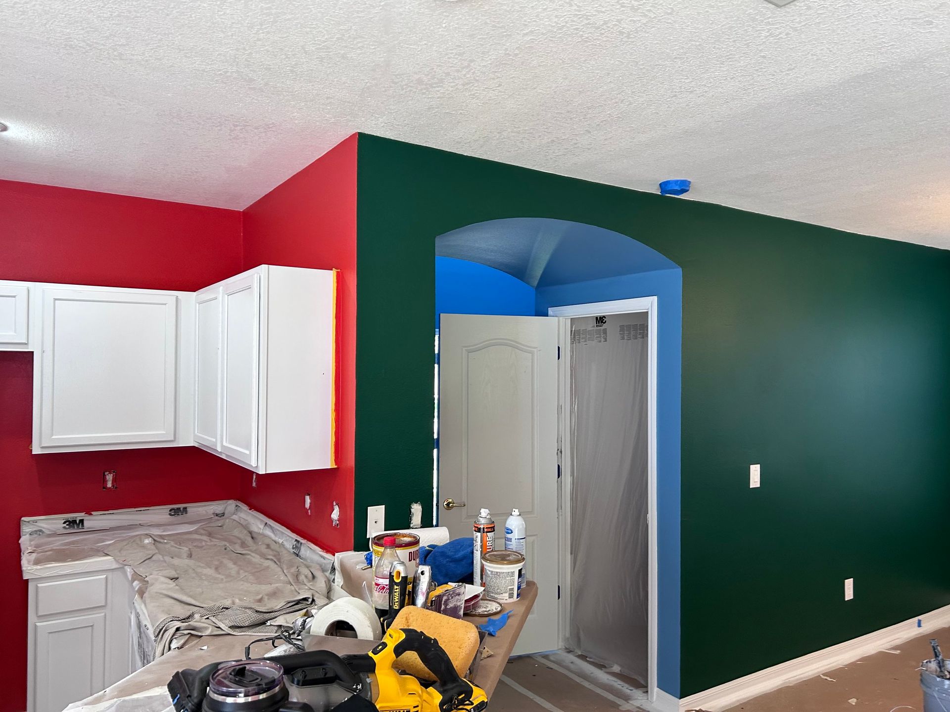 A kitchen that is being painted red green and blue