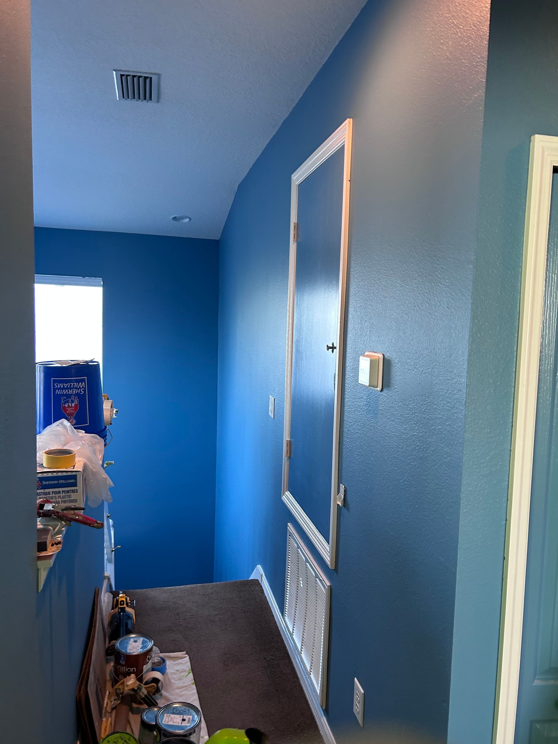 A bathroom with blue walls and a mirror