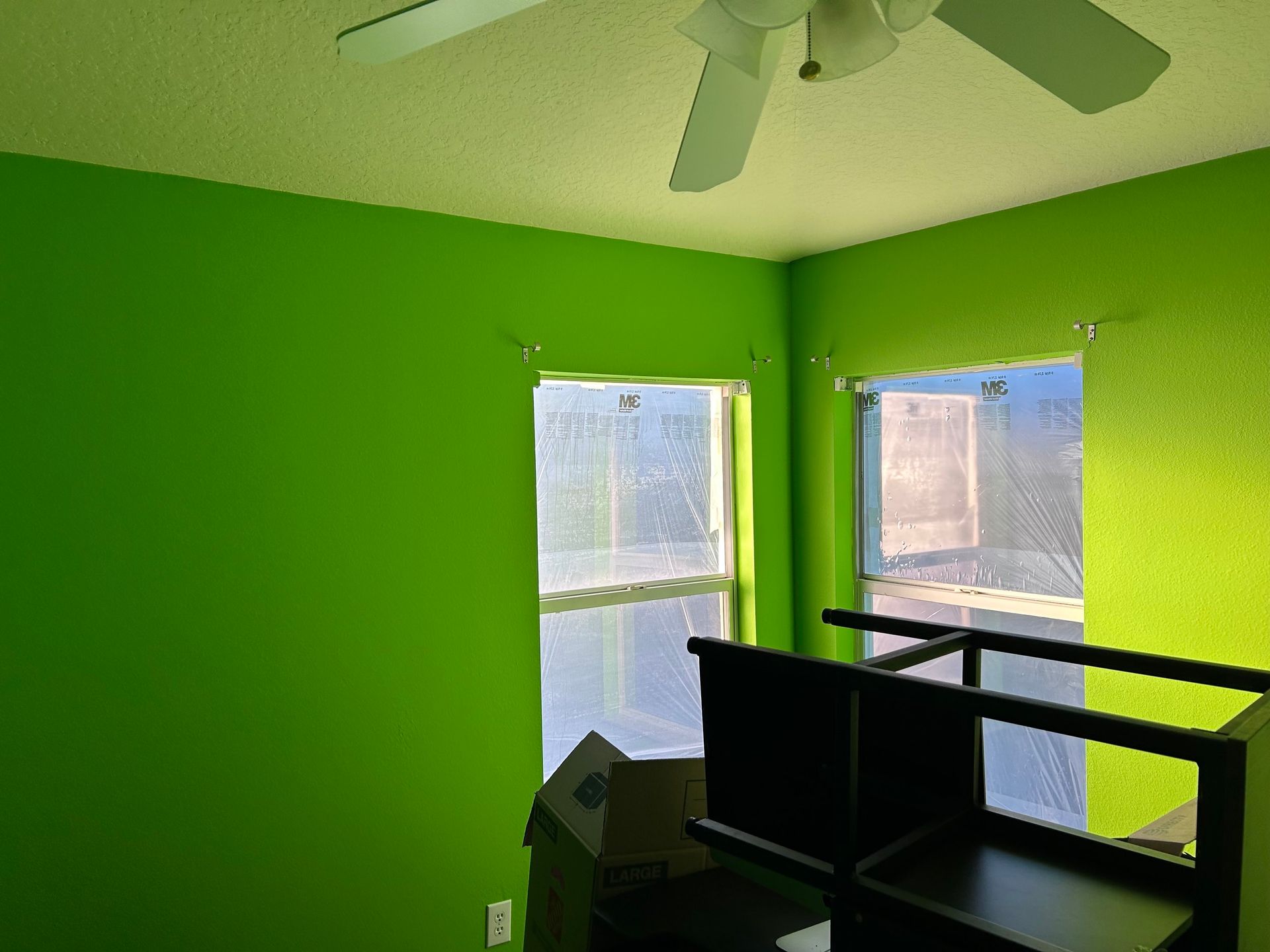 A room with green walls and a ceiling fan