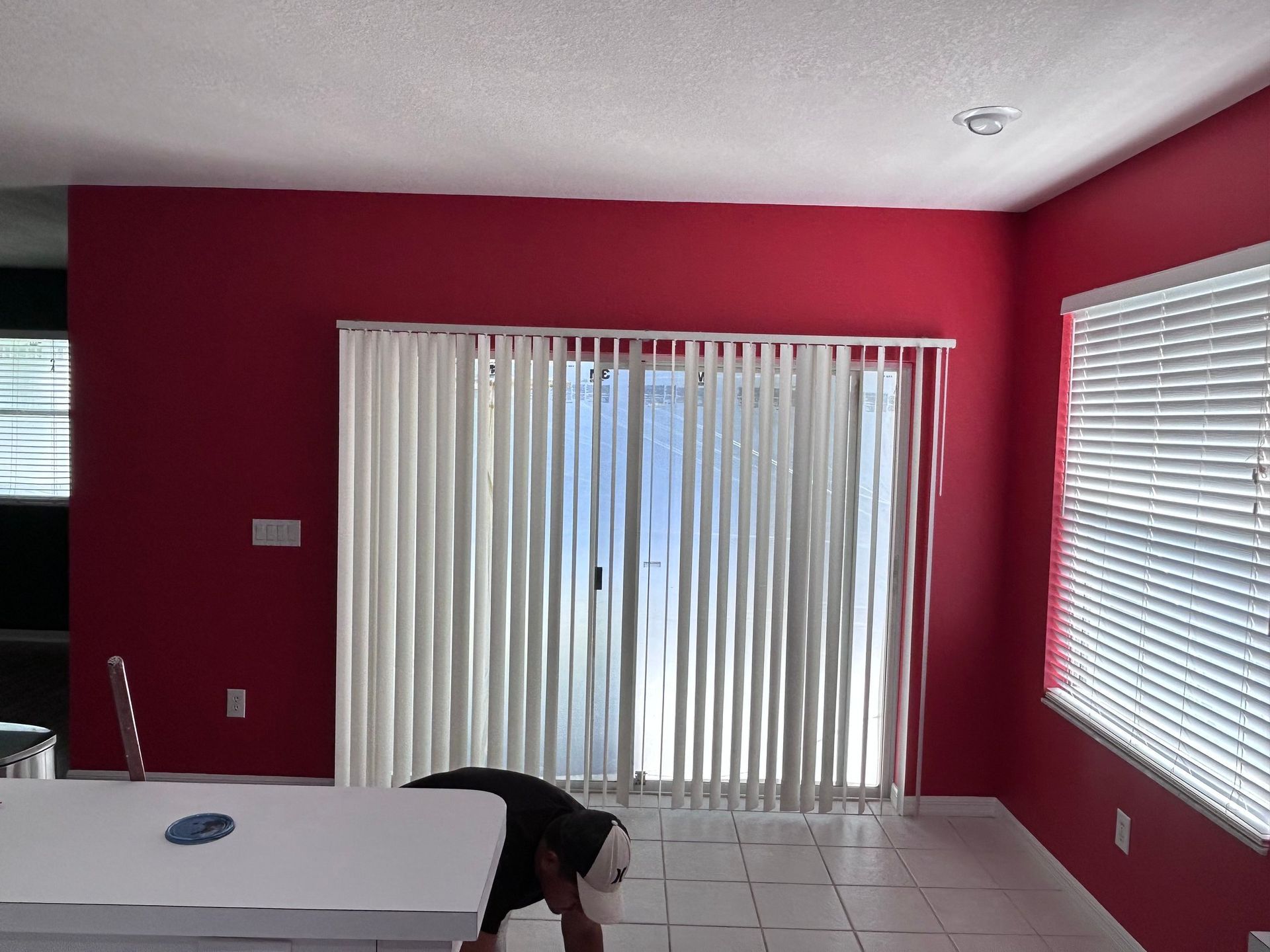 A room with red walls and white blinds