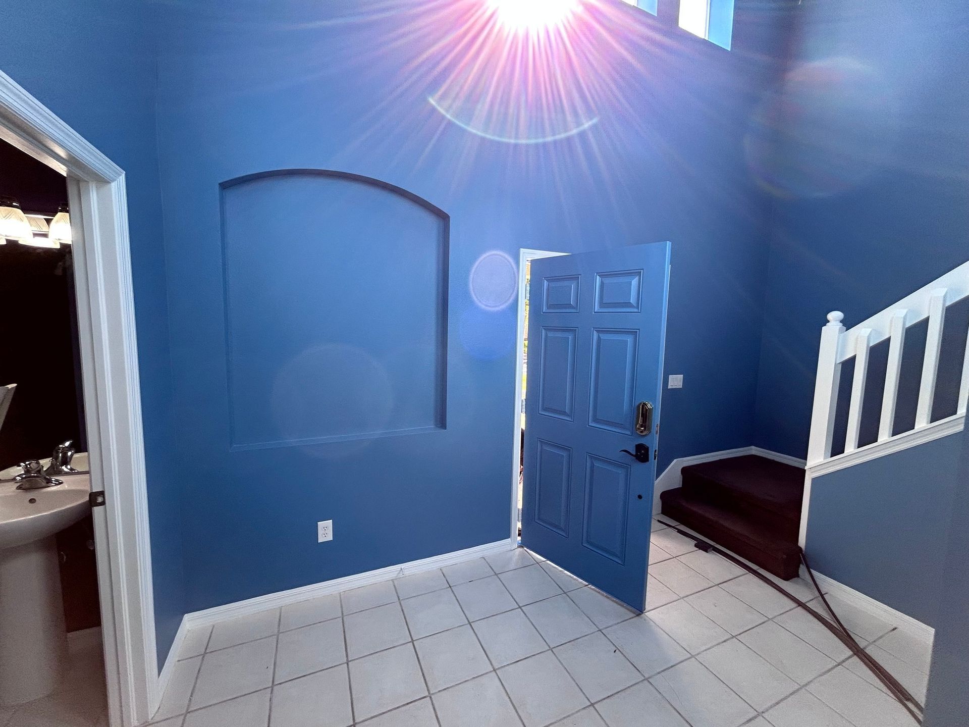 An empty room with blue walls and a blue door