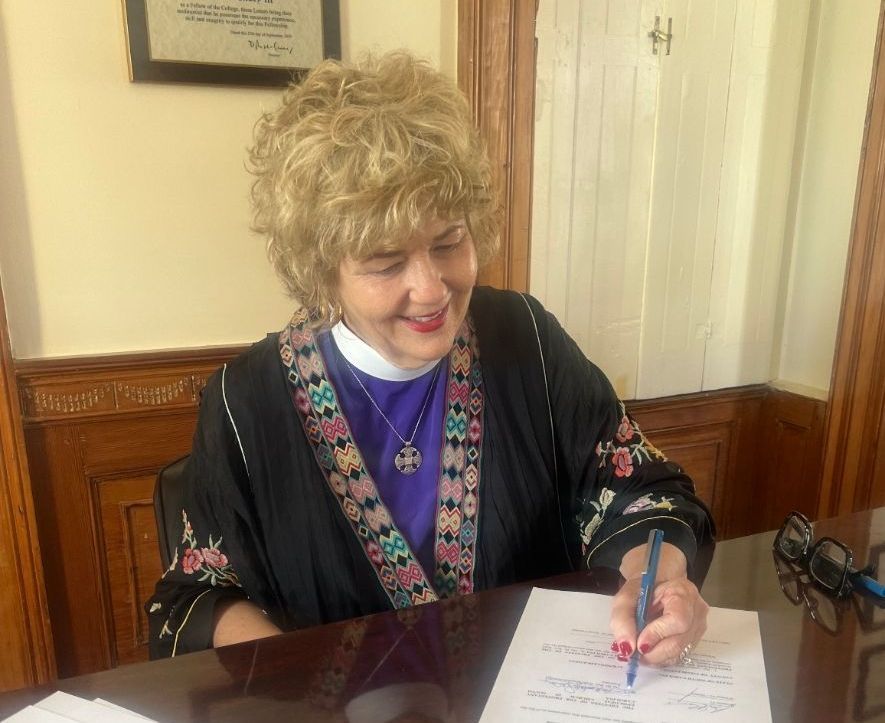 Bishop Ruth signing for the purchase of land for a new home for Messiah