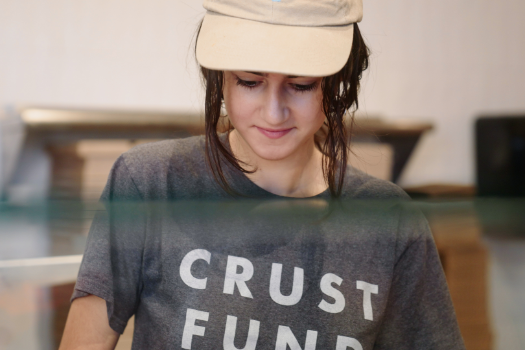 A woman wearing a hat and a shirt that says crust fund