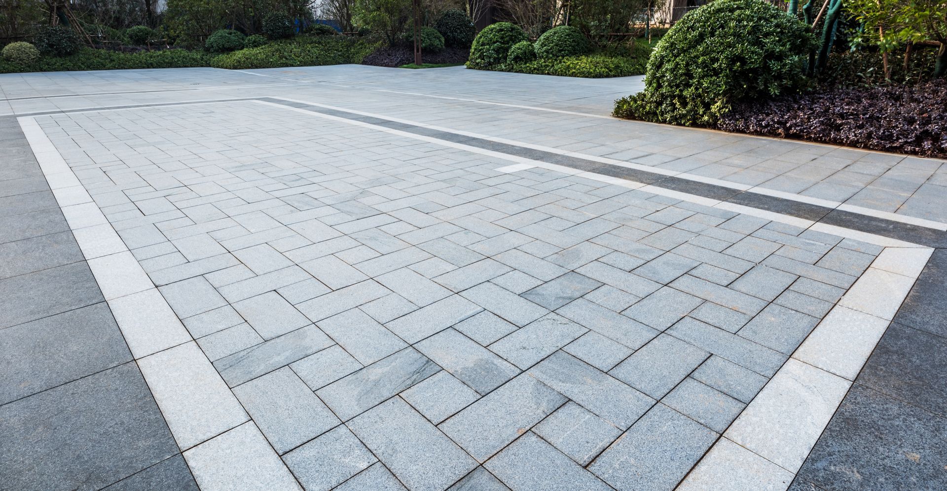 A brick driveway with a white line on the side of it.