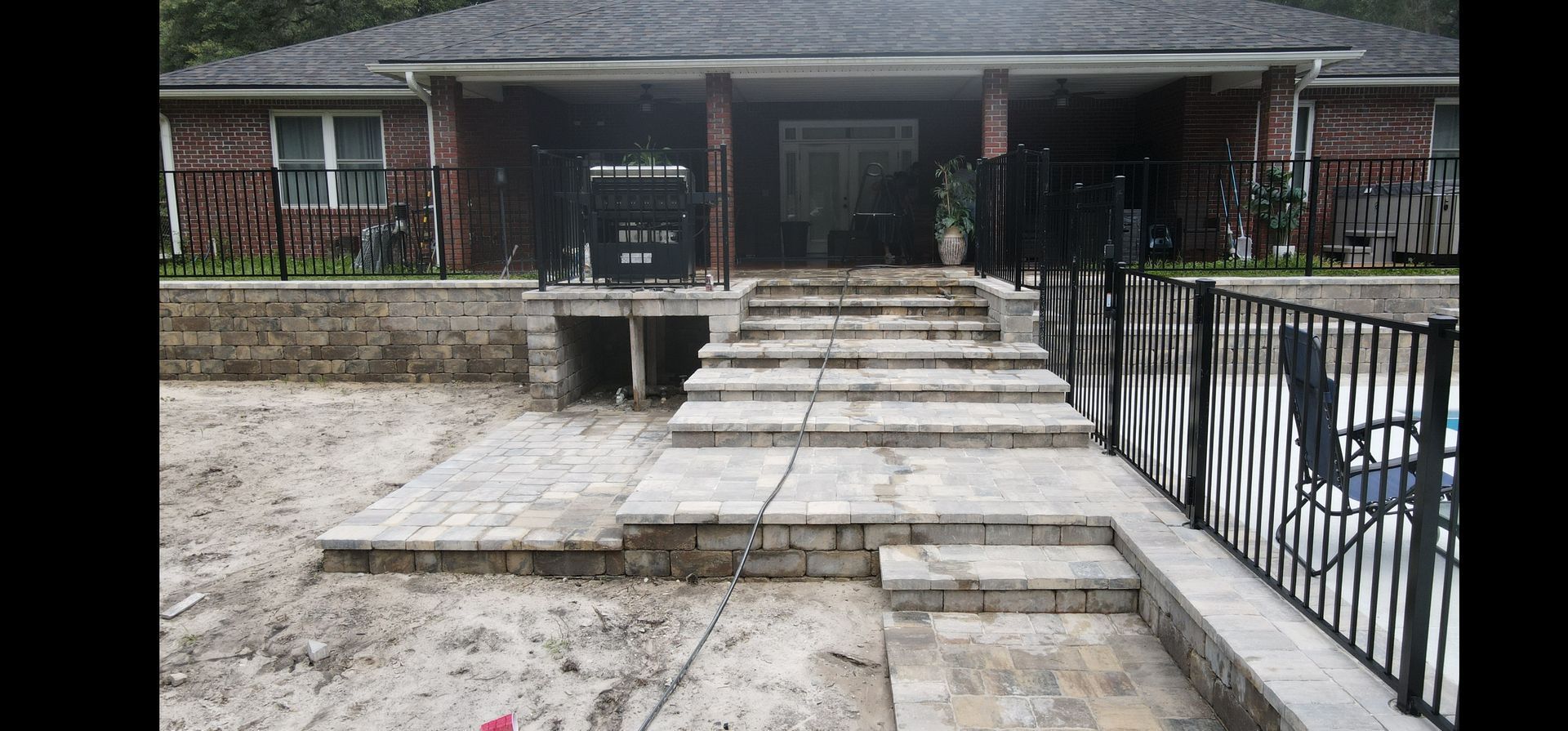 A brick house with stairs leading up to the front door.