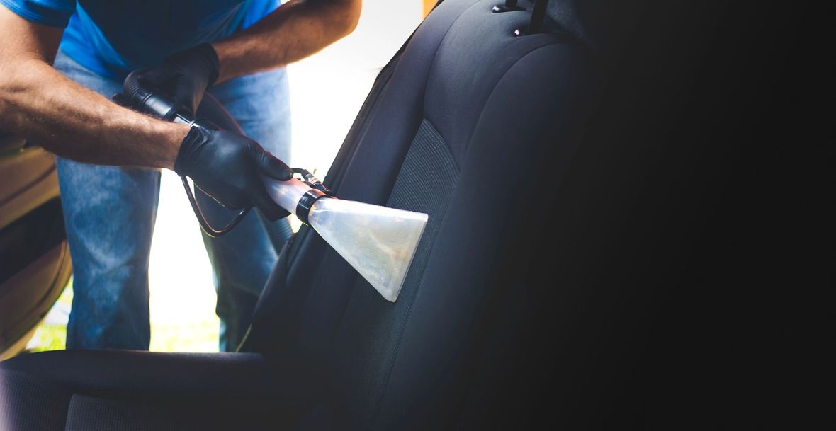 Una persona con i guanti utilizza un computer portatile che visualizza schemi di diagnostica del motore per ispezionare il cofano aperto di un'auto.