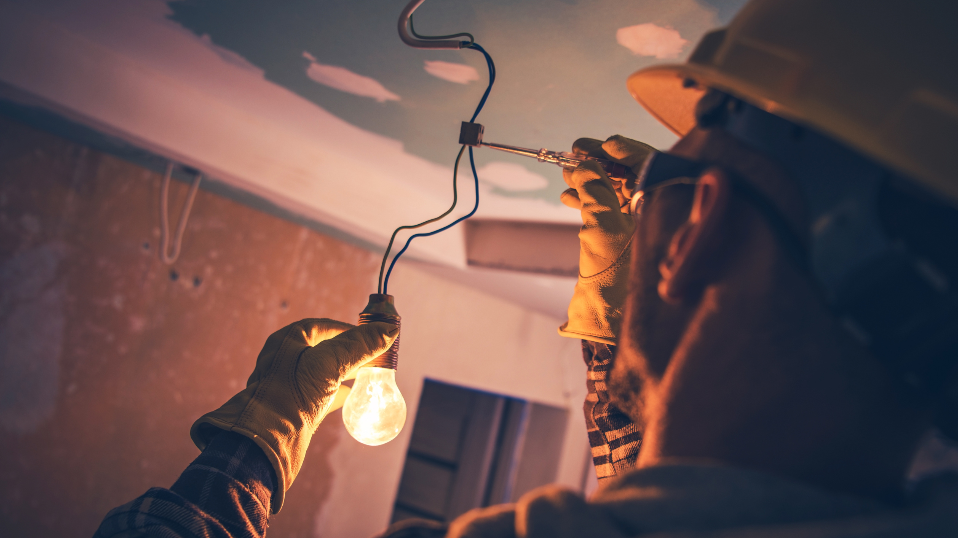 A man is holding a light bulb in his hand.