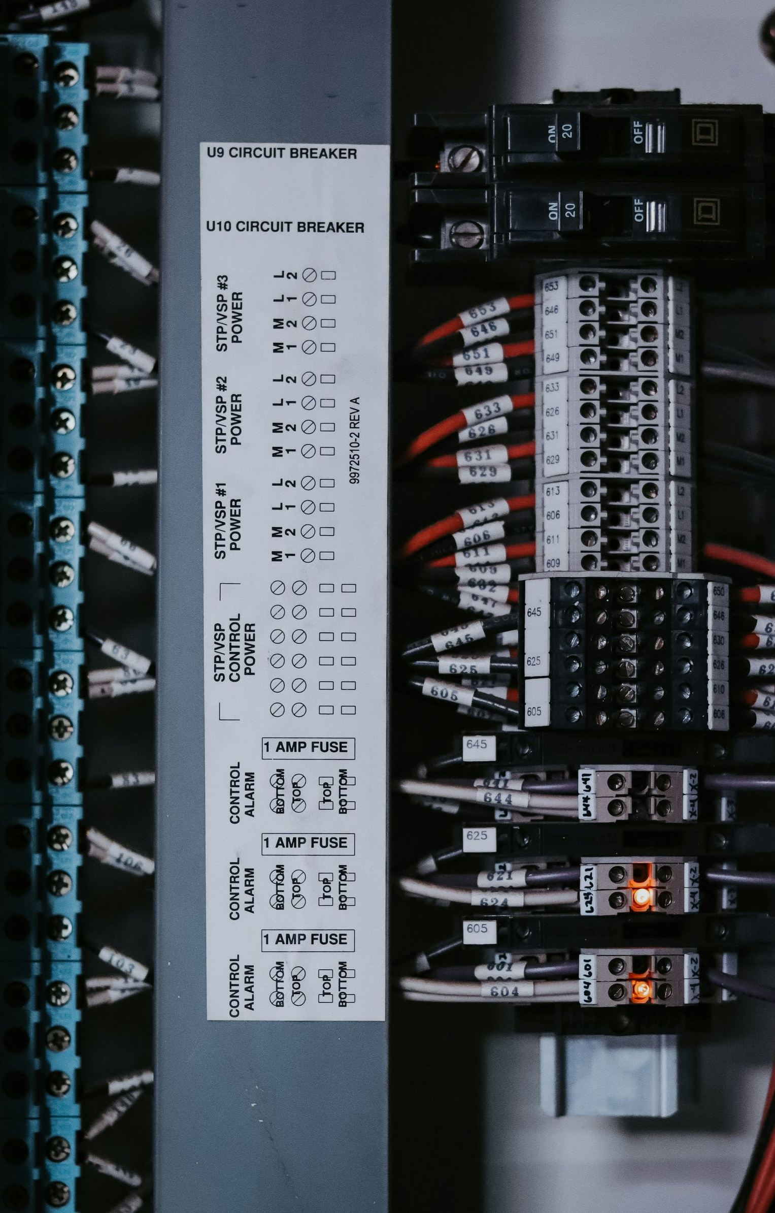 Electrical panel with wires connected to terminals, labeled with text.