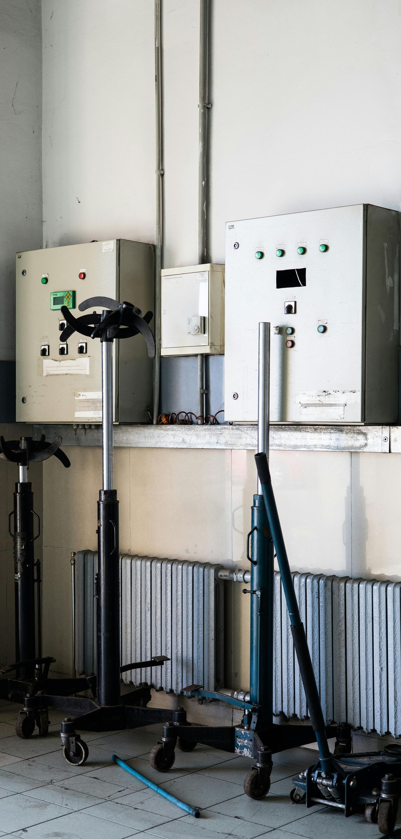 Three rolling equipment stands in a room with electrical boxes.