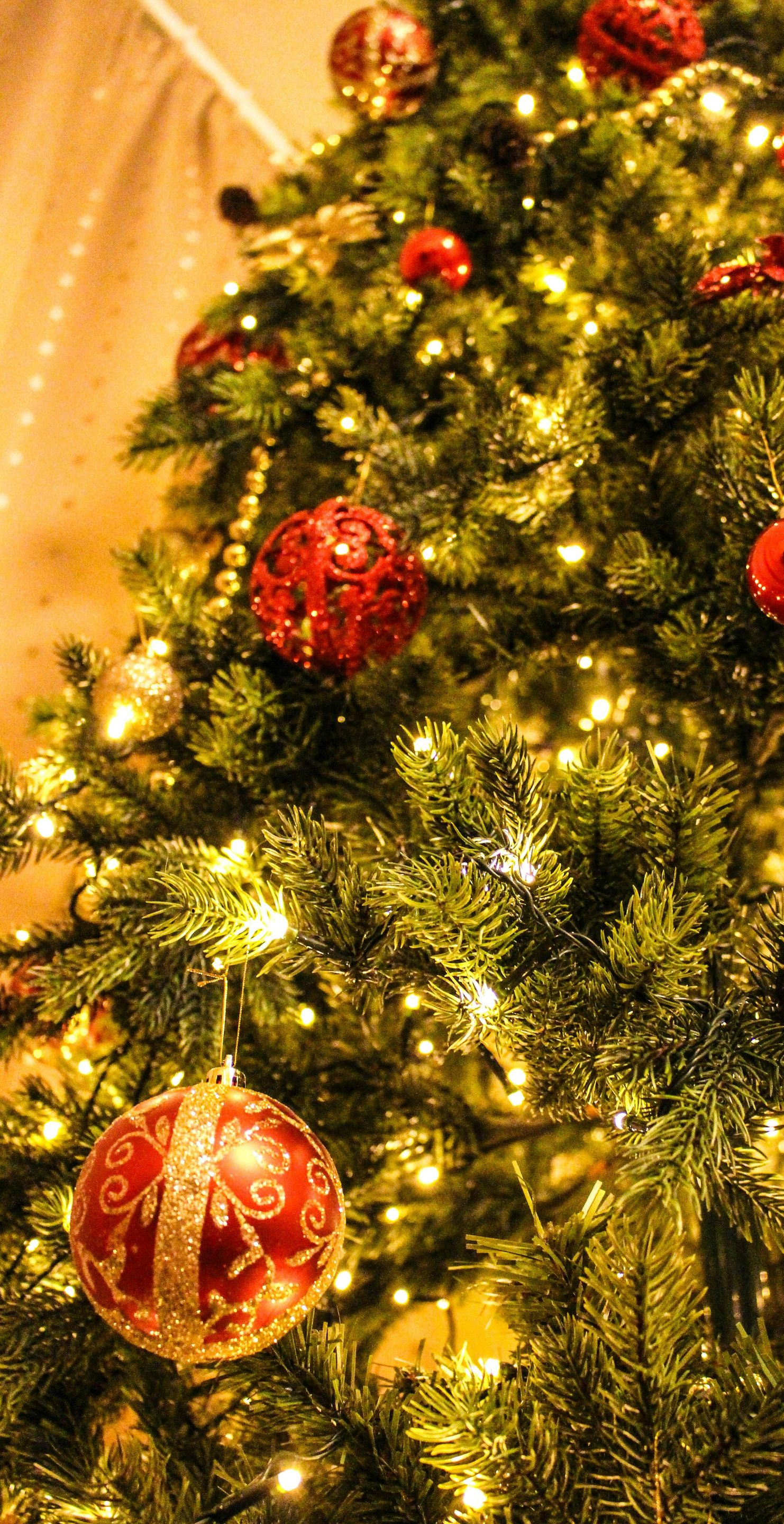 Christmas tree decorated with red ornaments and lights.