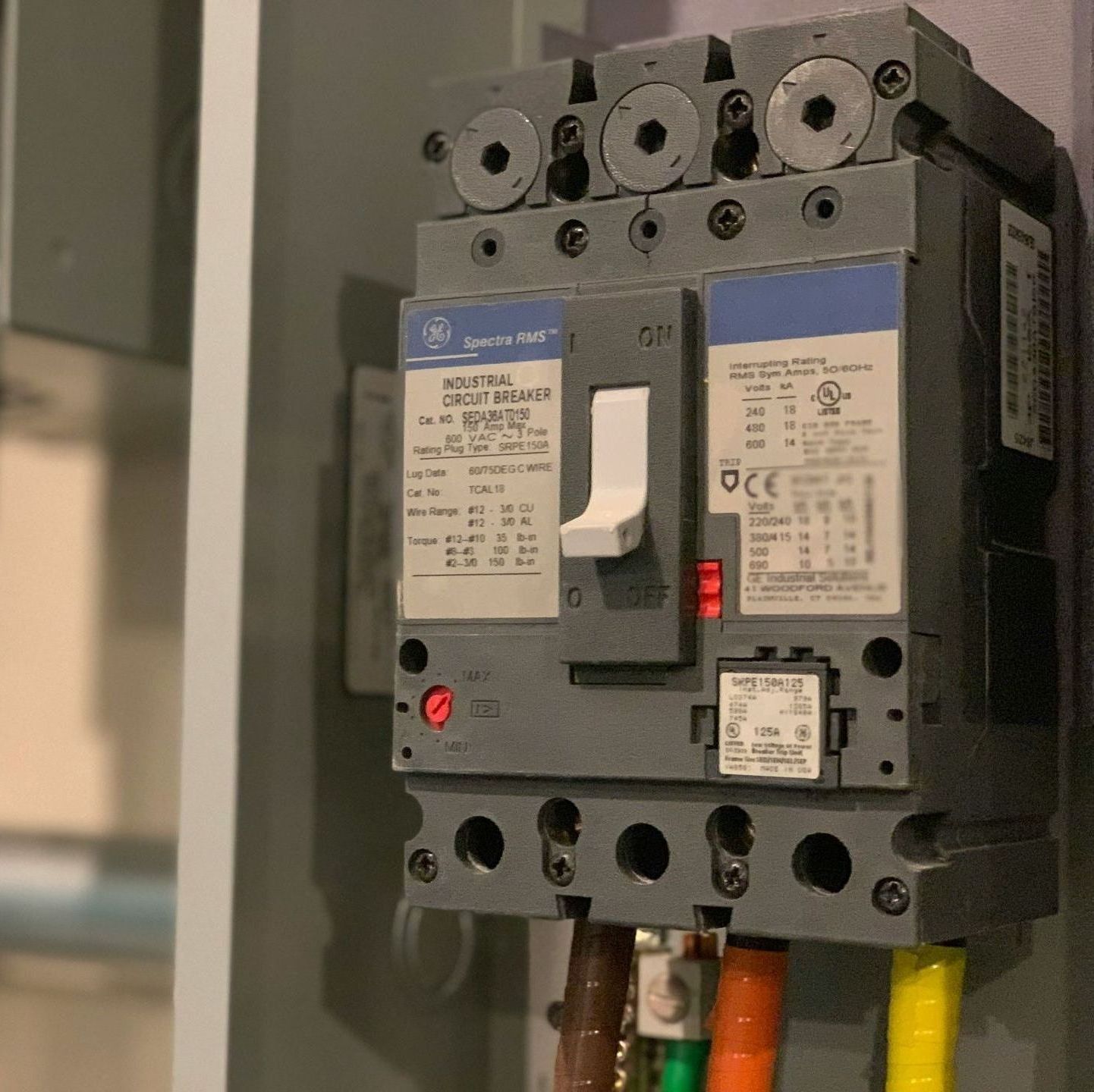 Circuit breaker mounted on a gray panel; switch in the