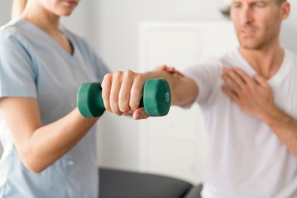 Patient Holding Dumbbells Hand Weights — PhysioCare Townsville In Thuringowa Central, QLD