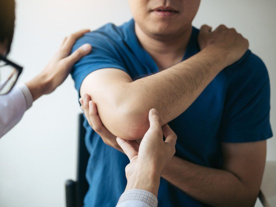 Physical Therapists Are Checking Patients Elbows at the Clinic — PhysioCare Townsville In Thuringowa Central, QLD