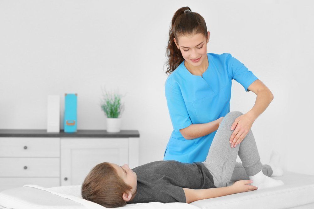 PhysiotheRapist Working With Children Patient in Clinic — PhysioCare Townsville In Thuringowa Central, QLD