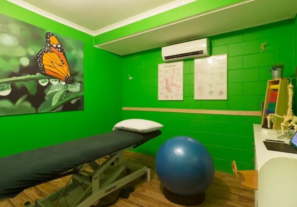 A Green Room With a Butterfly Painting on the Wall — PhysioCare Townsville In Townsville, QLD
