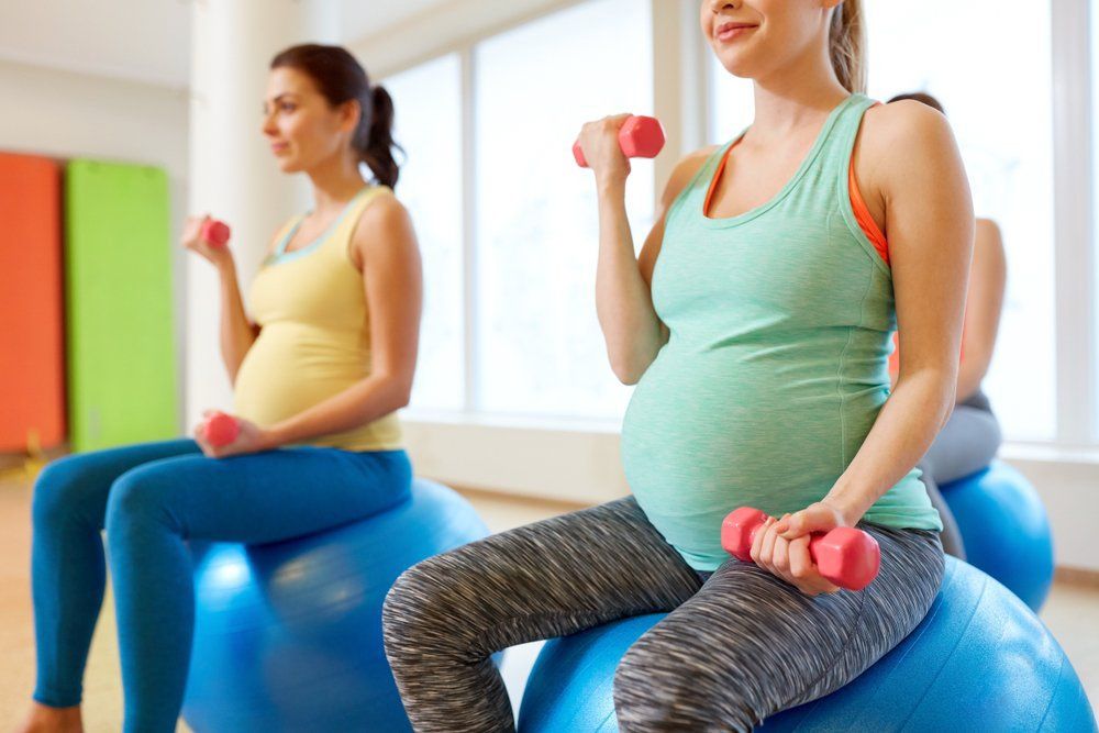 Group of Happy Pregnant Women With Dumbbells on Exercise — PhysioCare Townsville In Thuringowa Central, QLD