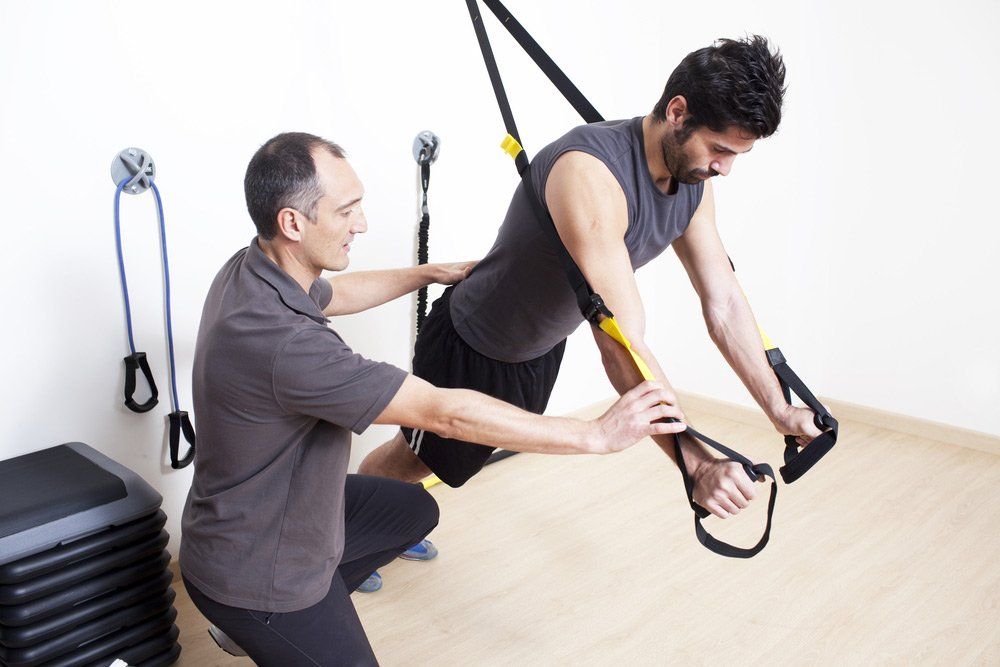 Physical Therapist With Patient While Doing Exercise Therapy — PhysioCare Townsville In Thuringowa Central, QLD