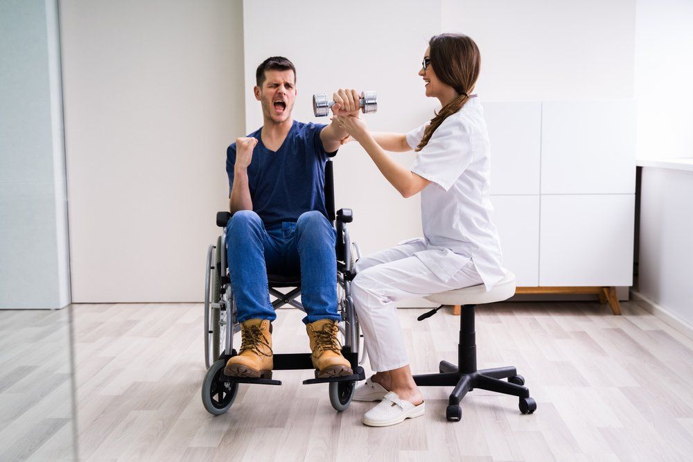 Therapist Assisting Happy Male Patient While Exercising With Dumbbell — PhysioCare Townsville In Thuringowa Central, QLD