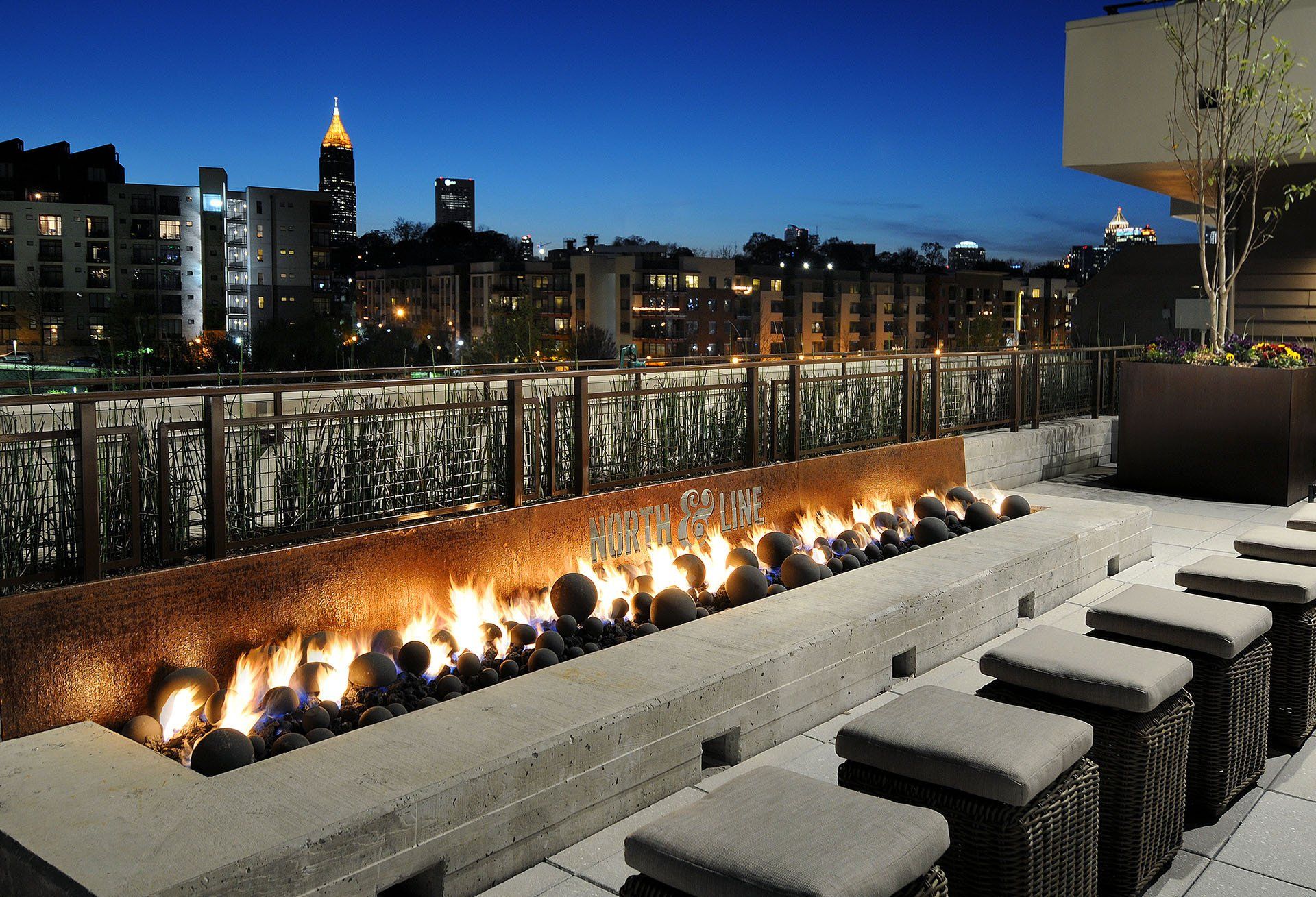 A fire pit with a city skyline in the background