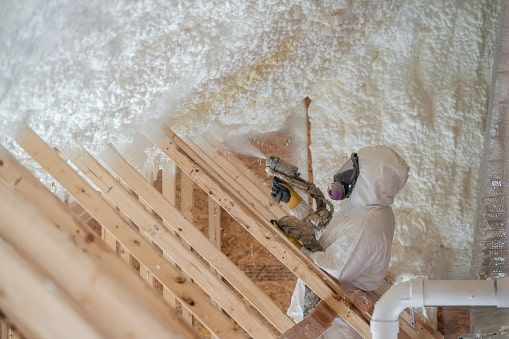 Worker Spraying Foam Insulation on Wall Panels in Chicagoland Home