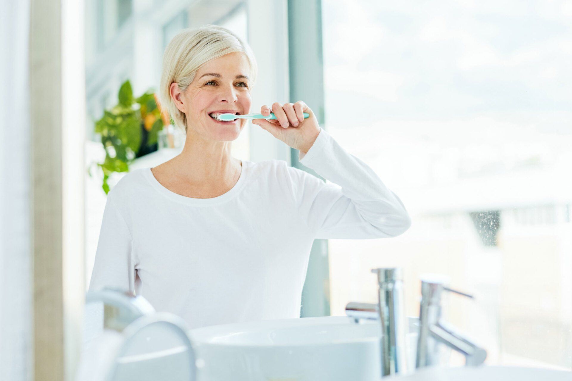 Woman Brushing Her Teeth — Eastpointe, MI — Universal Dental Center Woman Brushing Her Teeth — Eastpointe, MI — Universal Dental Center