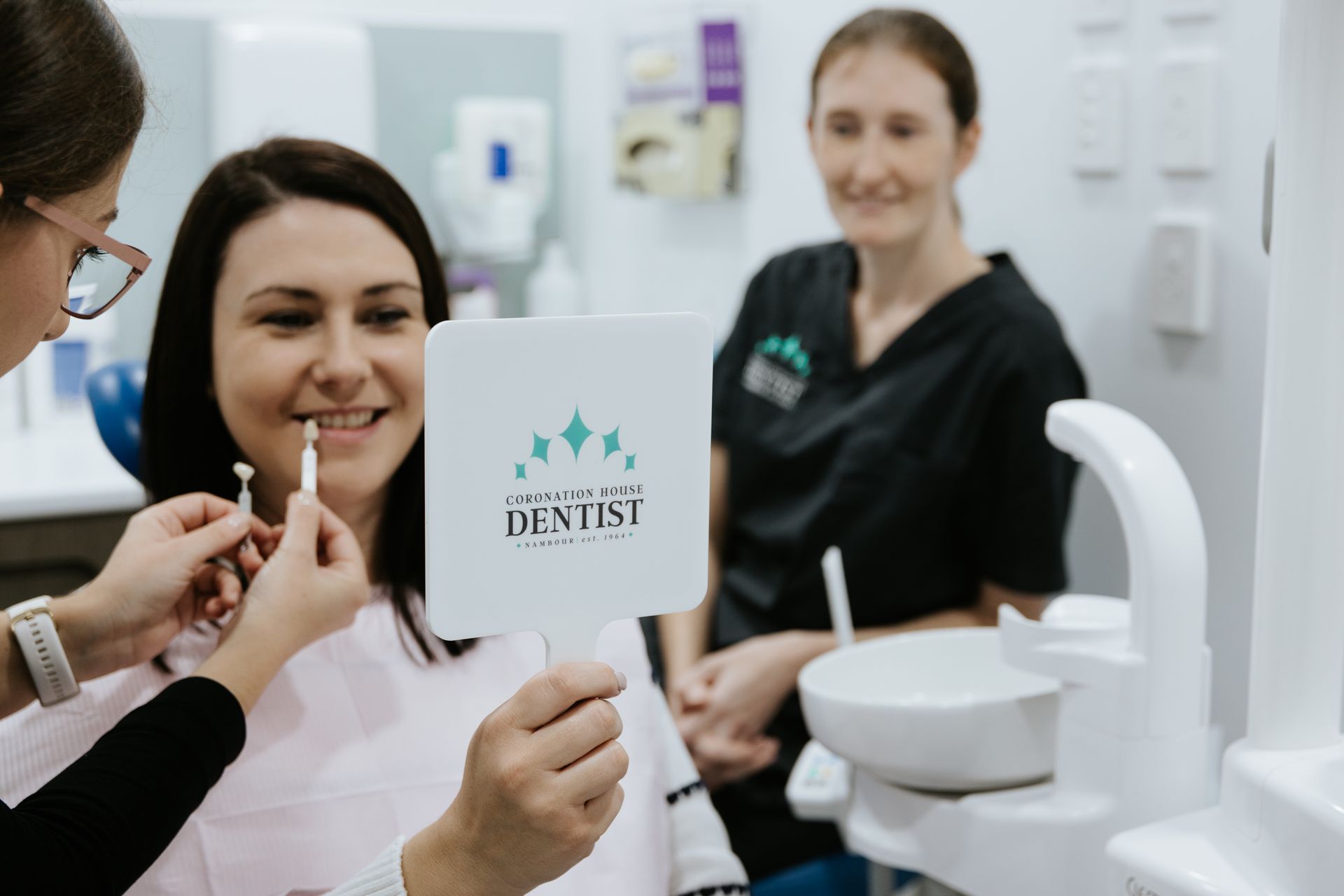 A Dentist is Examining a Woman 's Teeth in a Dental Office — Coronation House Dentist in Nambour, QLD