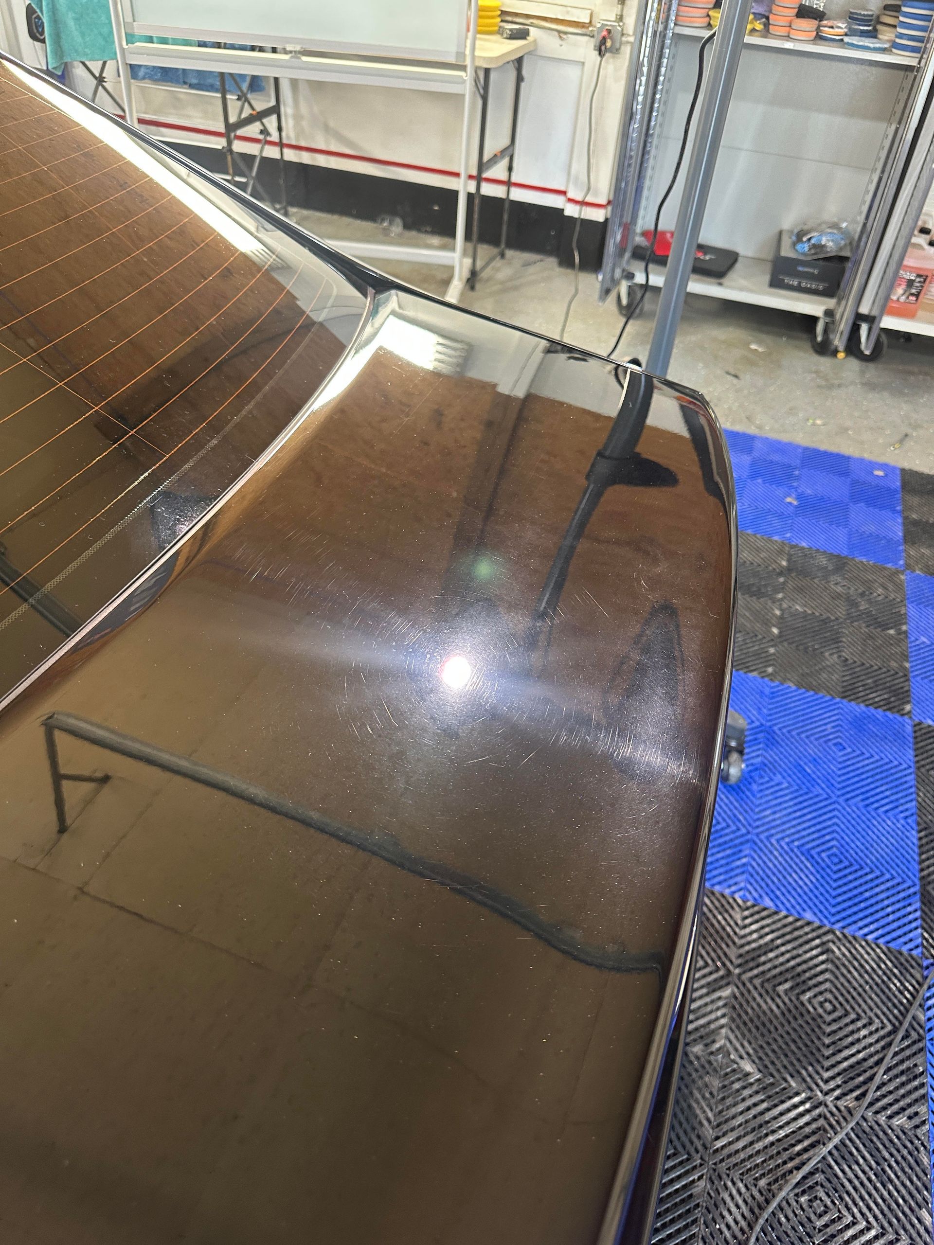 a close up of a car 's hood in a garage .