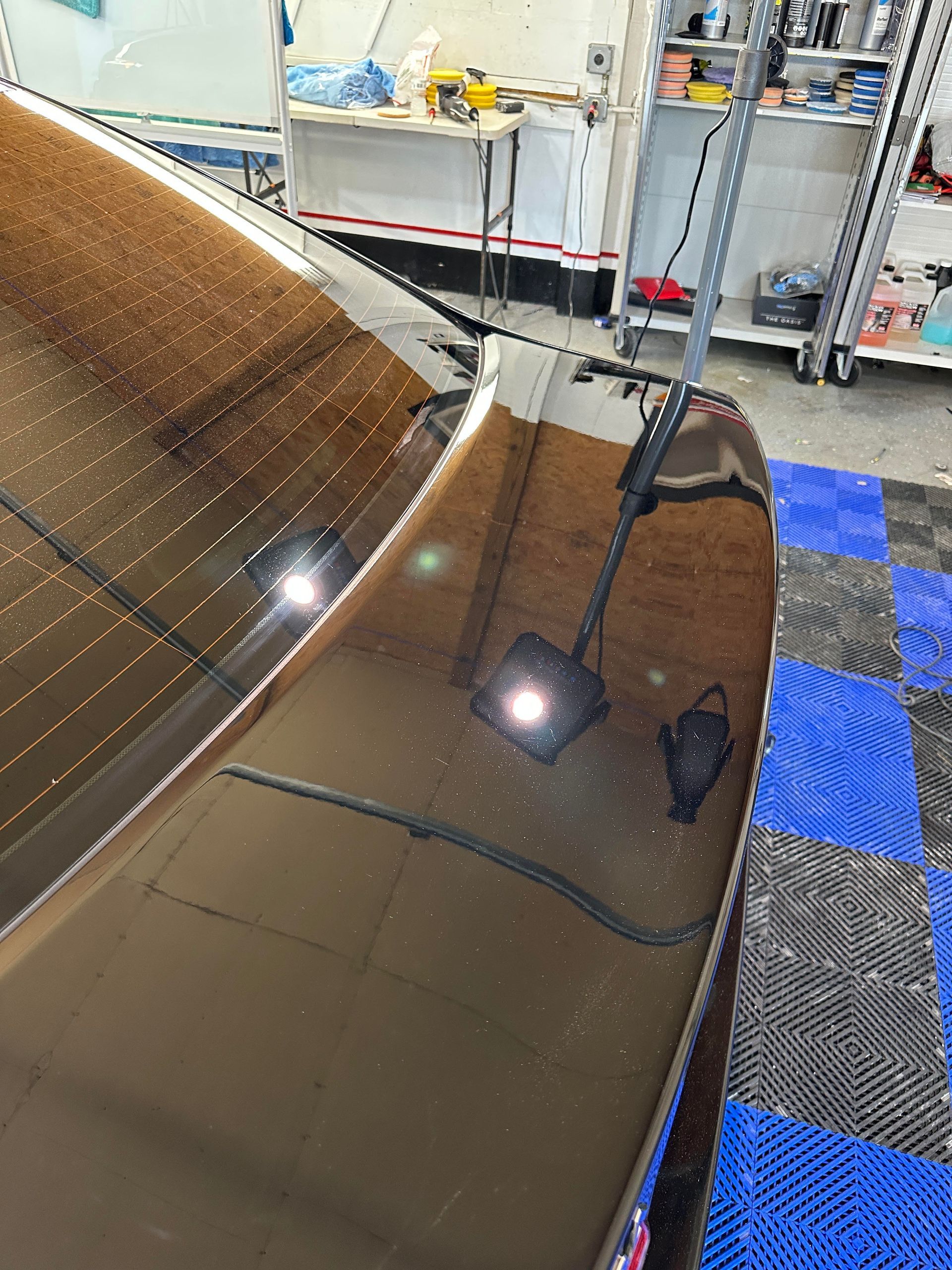 a close up of a car hood in a garage .