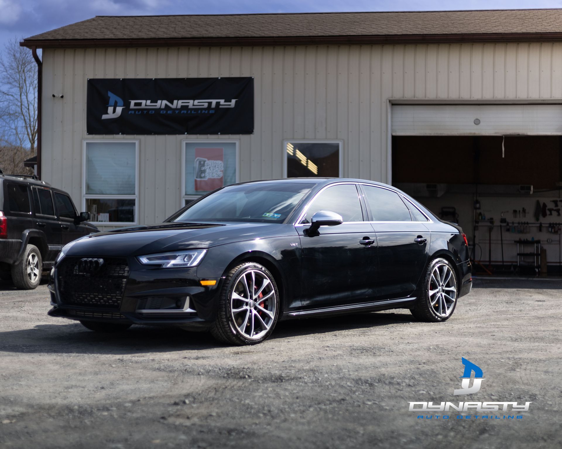 A black car is parked in front of a building.