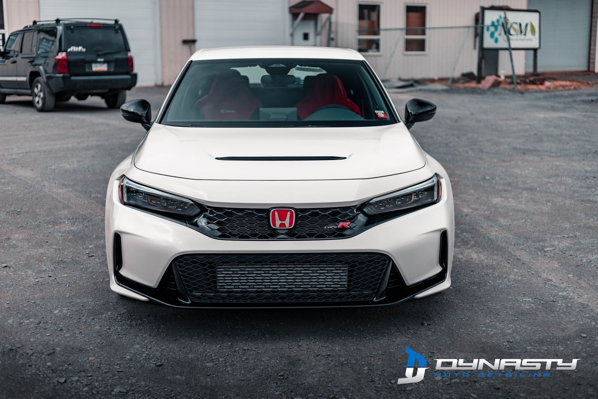 A white honda civic is parked in a parking lot.