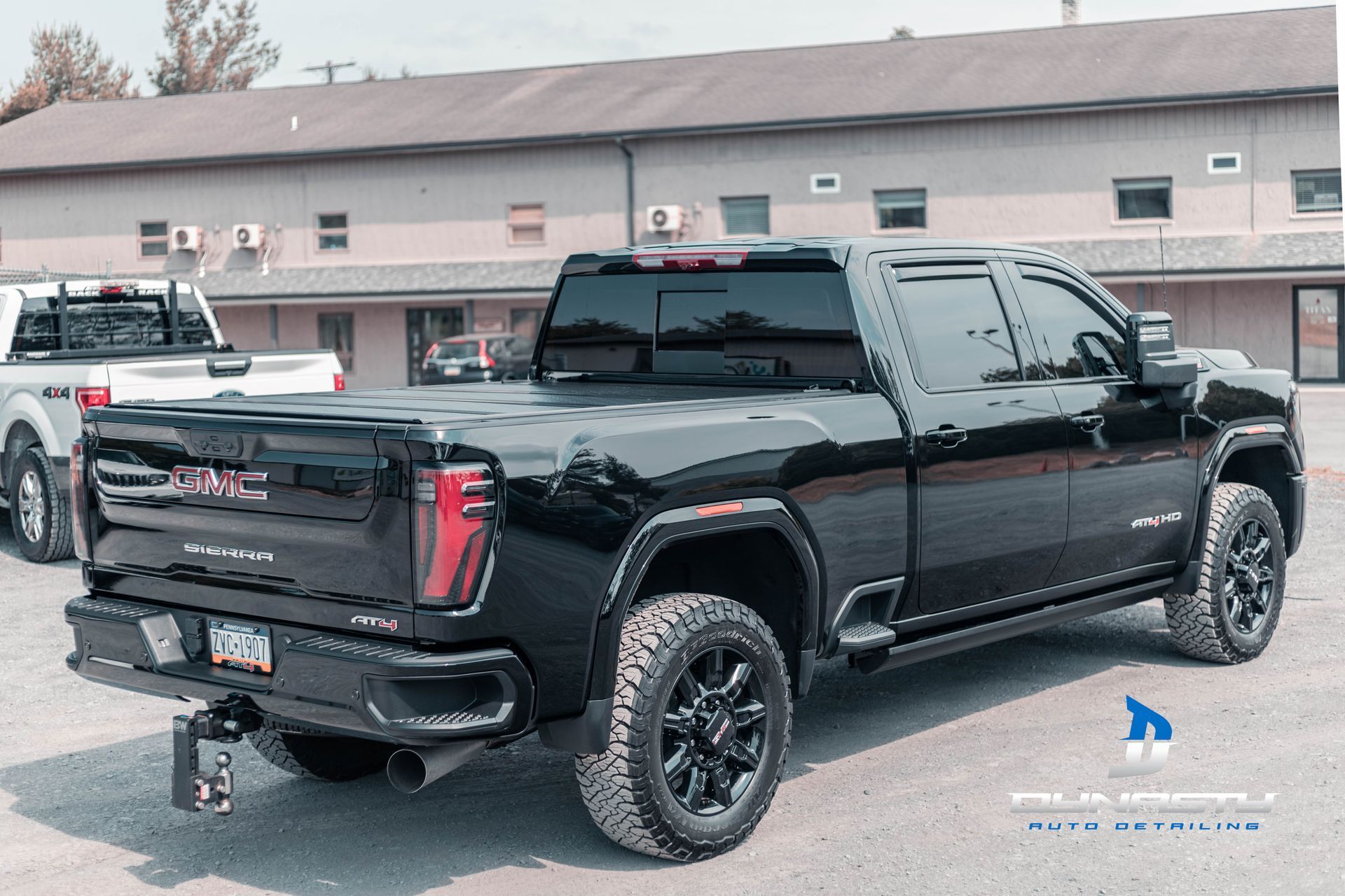 A black gmc truck is parked in front of a building.