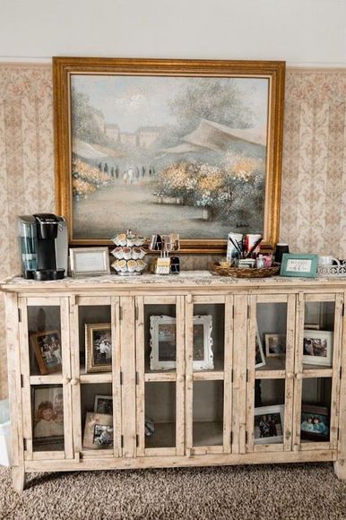Rustic sideboard with decor and a large framed landscape painting above it